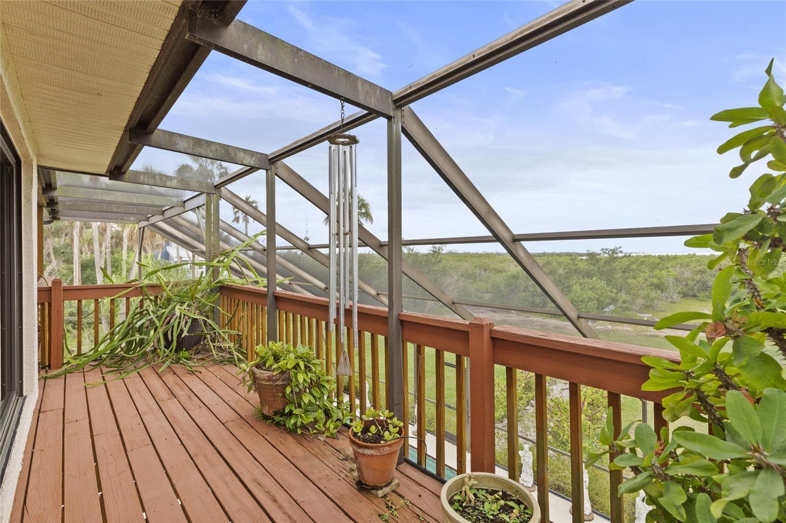 veranda runs the length of the back of the house and overlooks the pool and bay - 609 42ND STREET CT W, PALMETTO