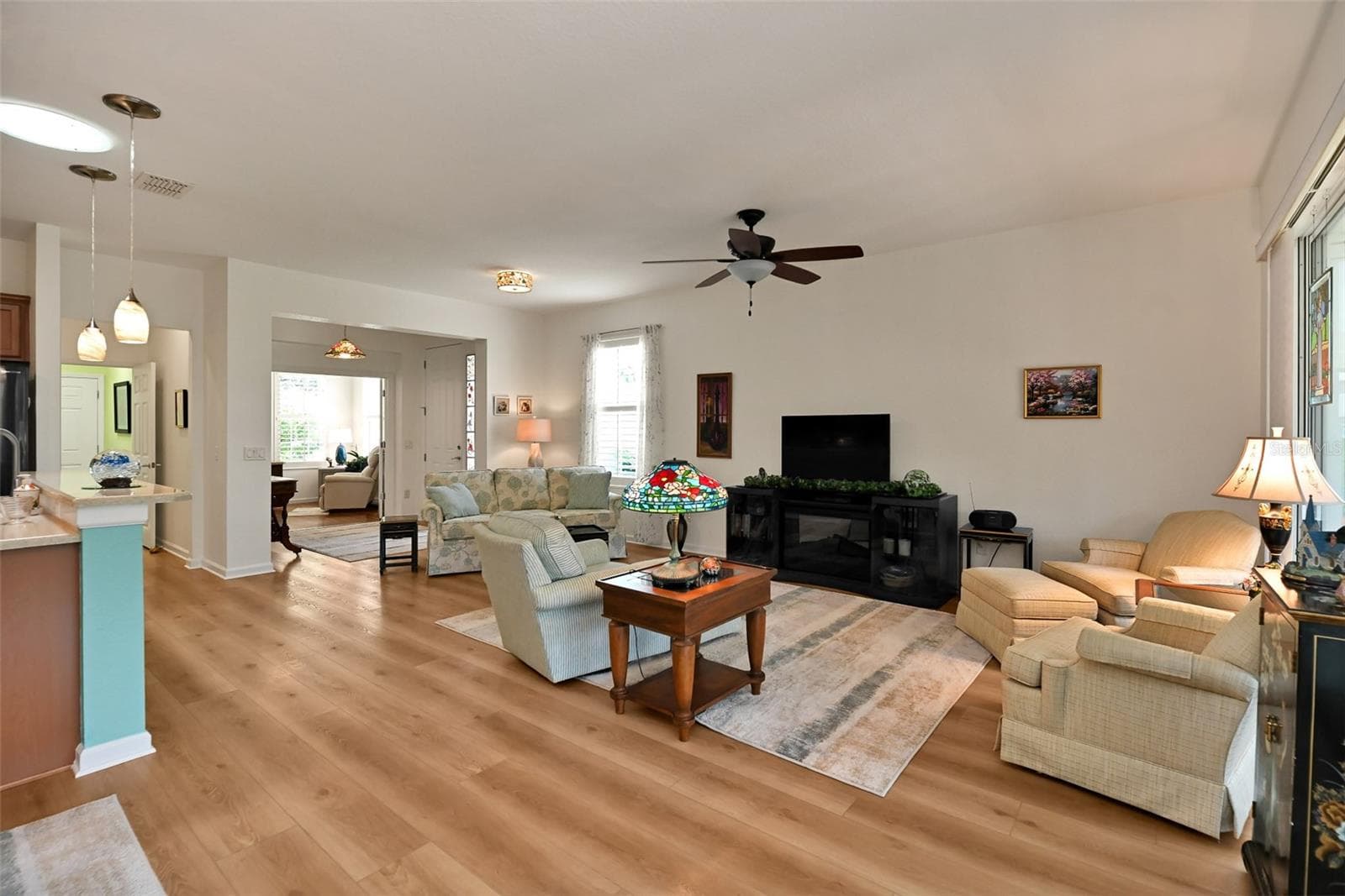 Open concept Living/Dining Areas with luxury vinyl plank flooring and included fireplace console. - 7139 SW 91ST CT, OCALA