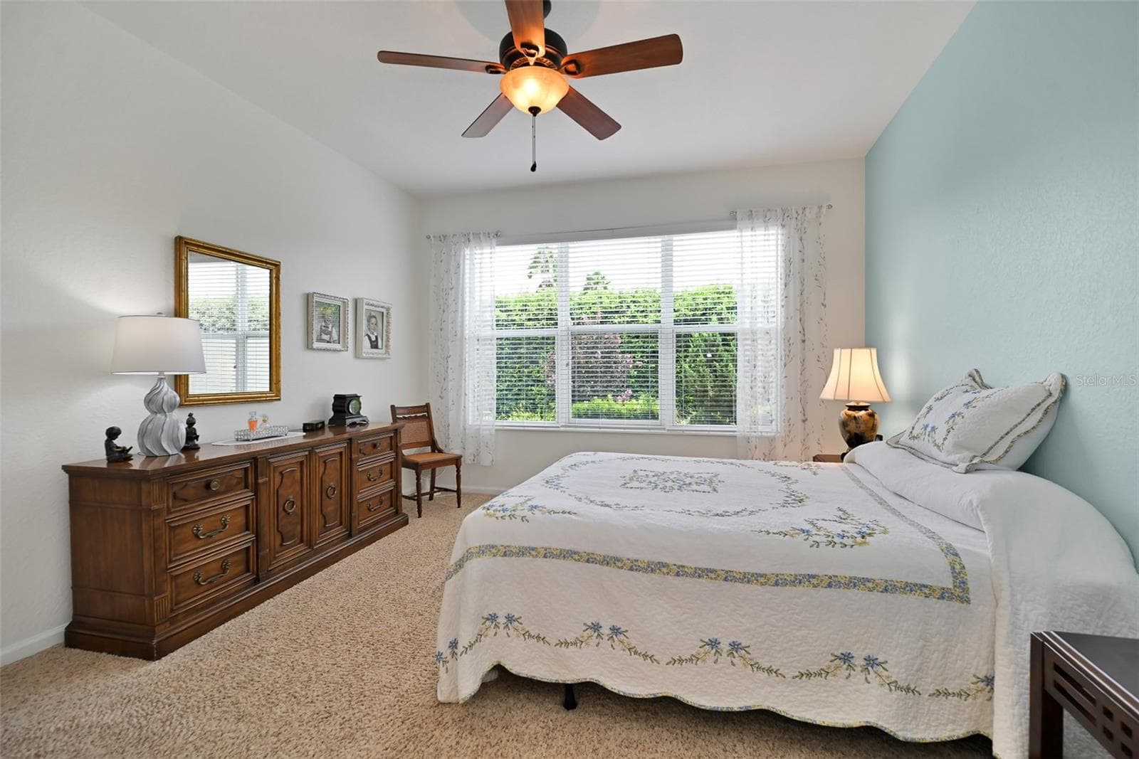 Primary bedroom with ceiling fan & ensuite bath - 7139 SW 91ST CT, OCALA