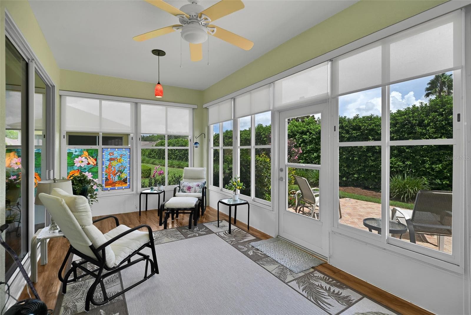 Enclosed lanai with shades, plank flooring, ceiling fan & pendant lighting - 7139 SW 91ST CT, OCALA