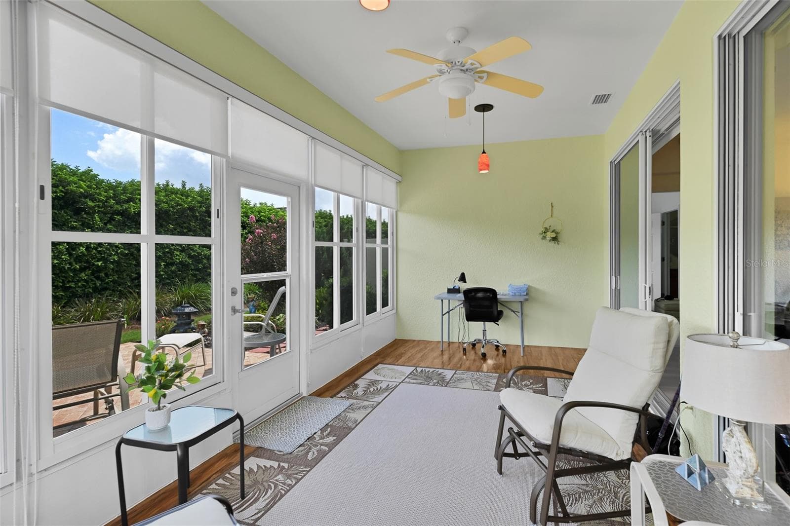 Enclosed lanai with shades, plank flooring, ceiling fan & pendant lighting - 7139 SW 91ST CT, OCALA