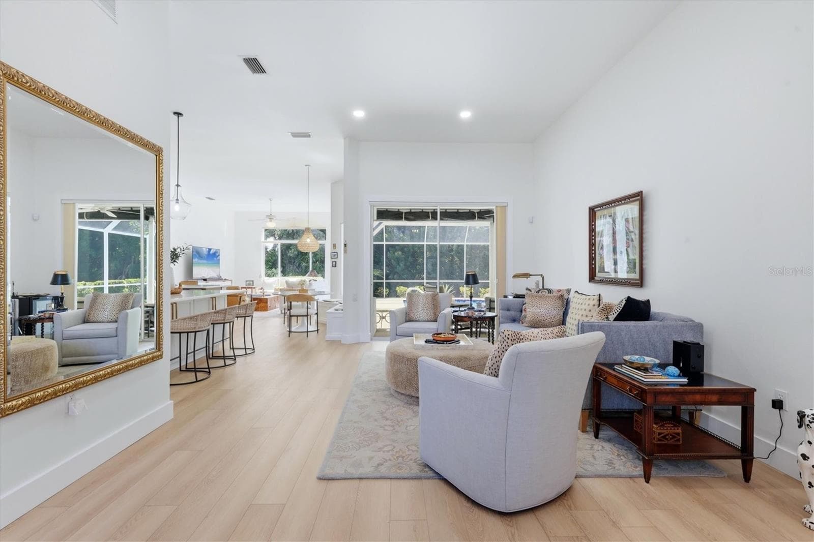 Living room at entry, sliders open to pool. - 8857 HAVENRIDGE DR, SARASOTA