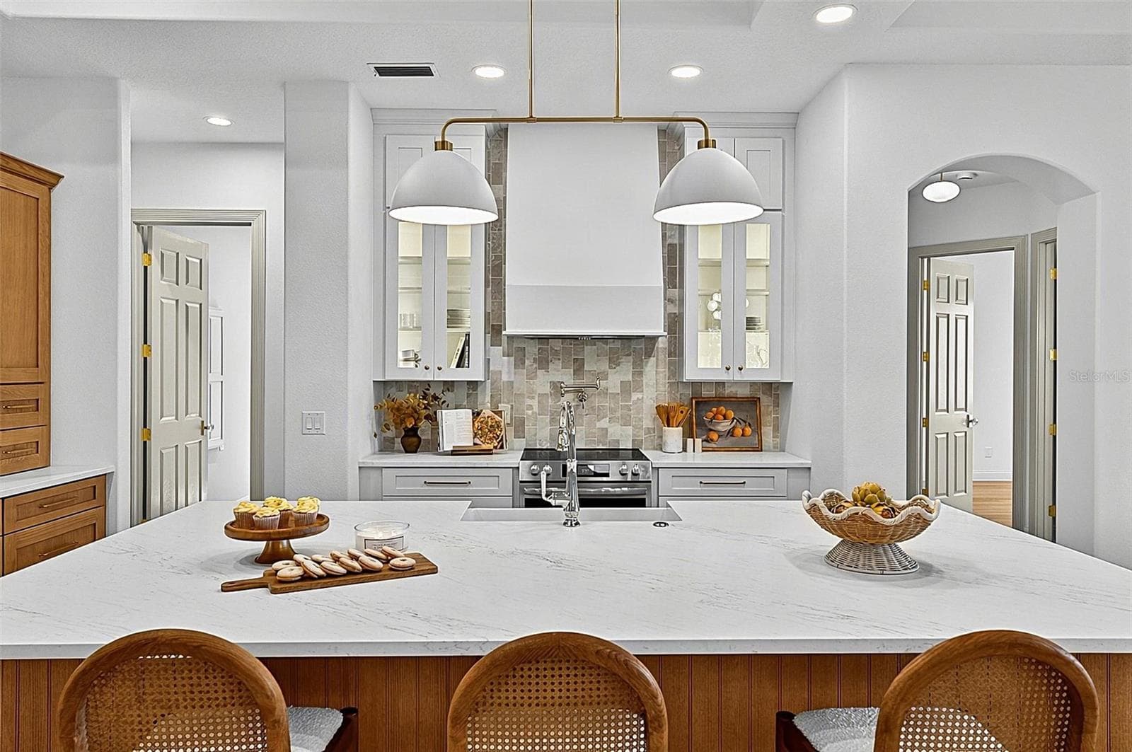 Elegant Centerpiece Kitchen Island with crafted wall of tile and lighted window cabinets - 17 GRANDVIEW DR, PALM COAST