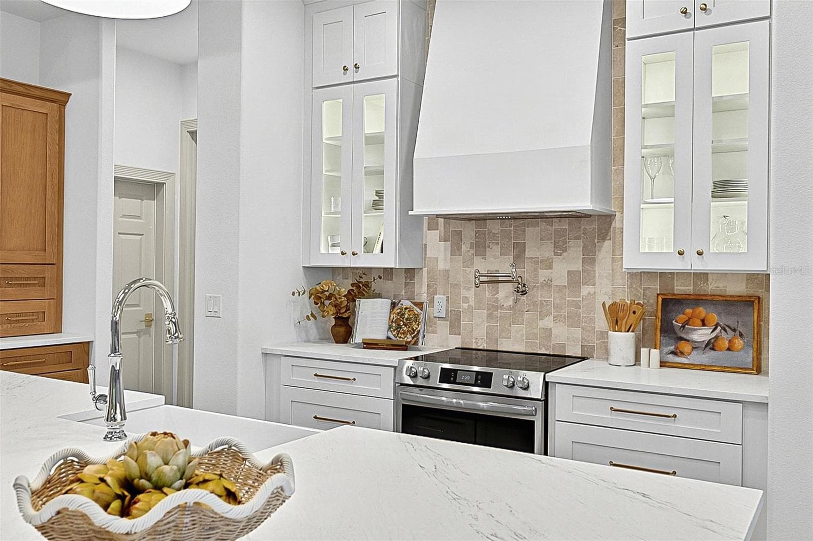Elegant Centerpiece Kitchen Island with crafted wall of tile and lighted window cabinets - 17 GRANDVIEW DR, PALM COAST