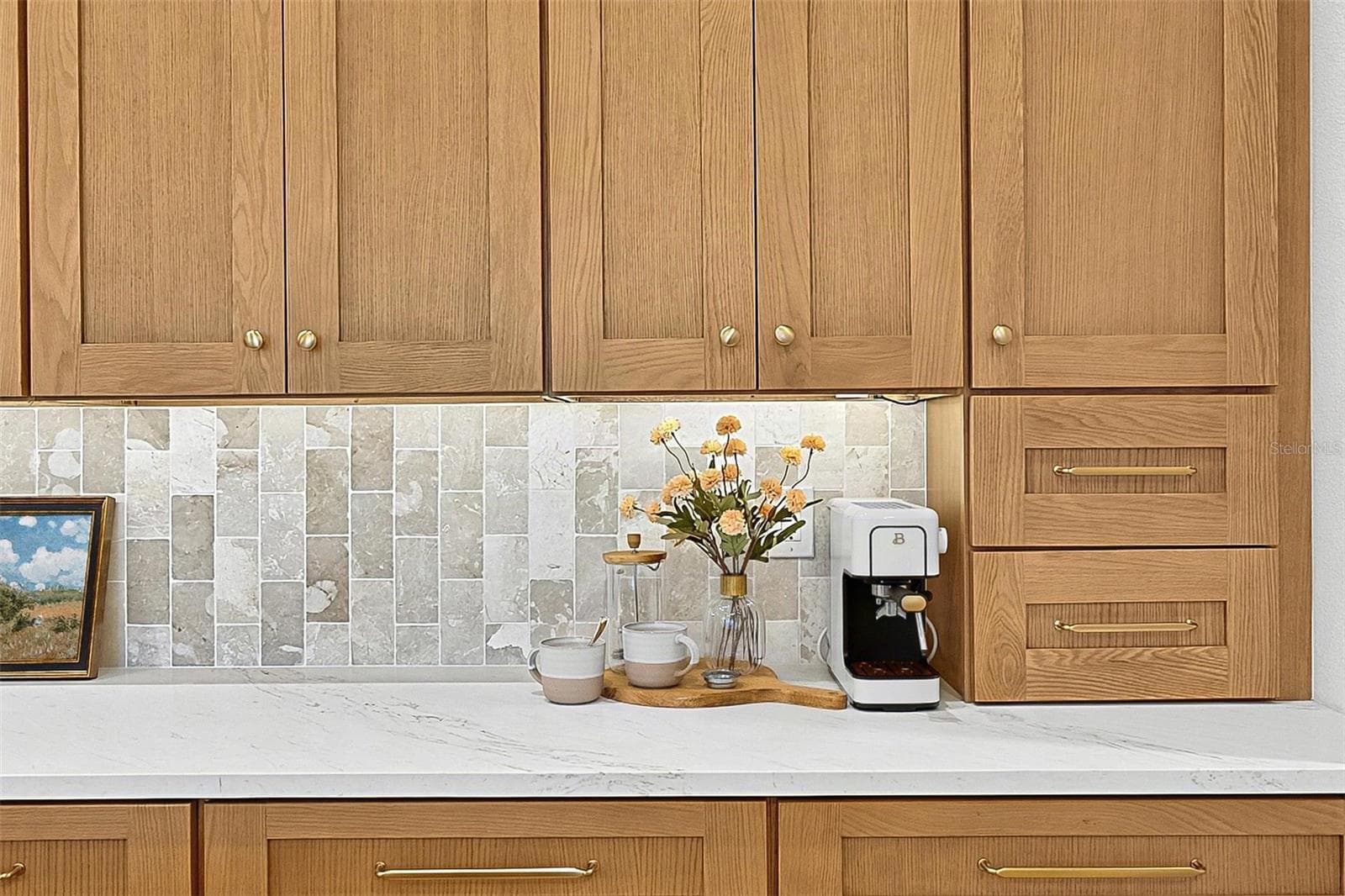 Full wall of Custom Wood soft close cabinets with under-mount lighting against the stunning tile and quartz countertops - 17 GRANDVIEW DR, PALM COAST