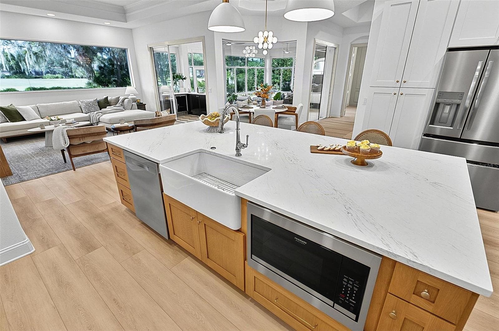 Kitchen Island with farm sink, dishwasher and microwave showing refrigerator with wall of pantry cabinets and family room - 17 GRANDVIEW DR, PALM COAST