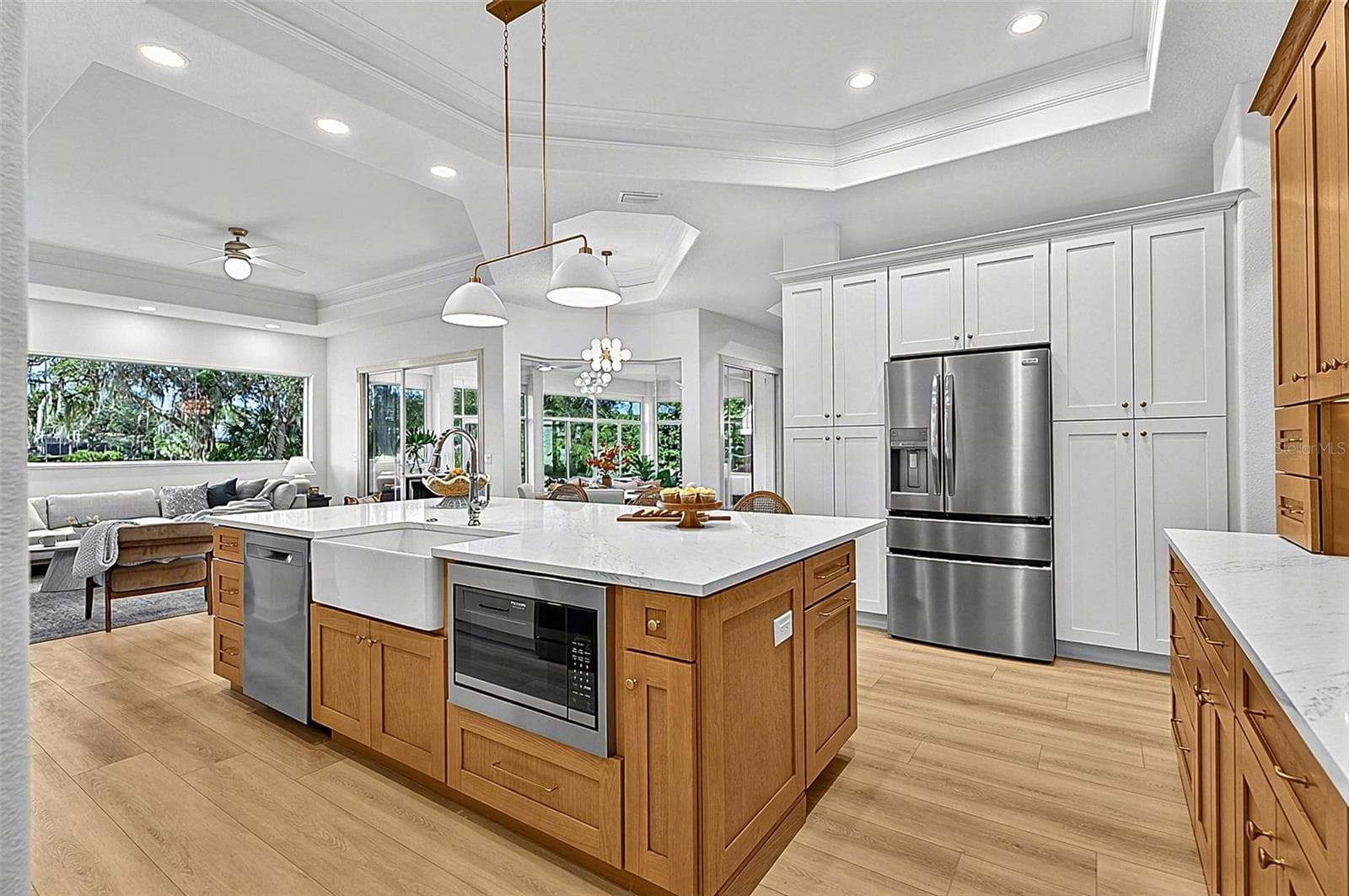 Kitchen Island with farm sink, dishwasher and microwave showing refrigerator with wall of pantry cabinets and family room - 17 GRANDVIEW DR, PALM COAST