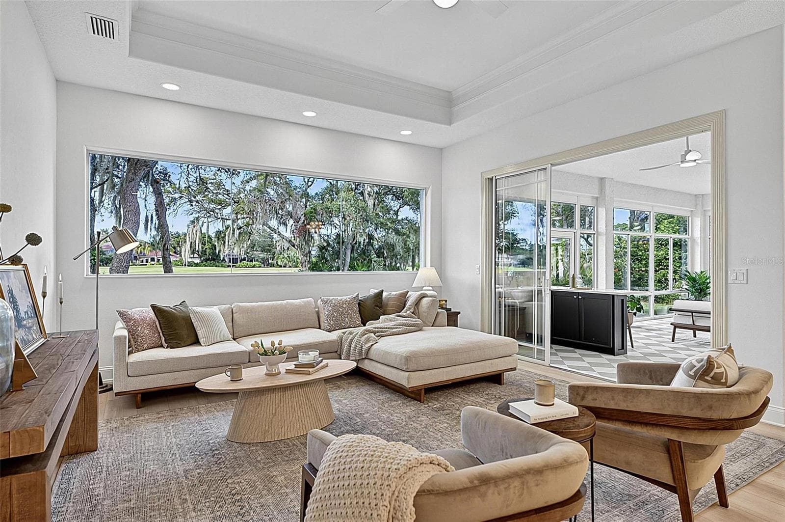 Family room with Stunning views through wall of window looking out to backyard and golf course with triple sliders onto the solarium - 17 GRANDVIEW DR, PALM COAST