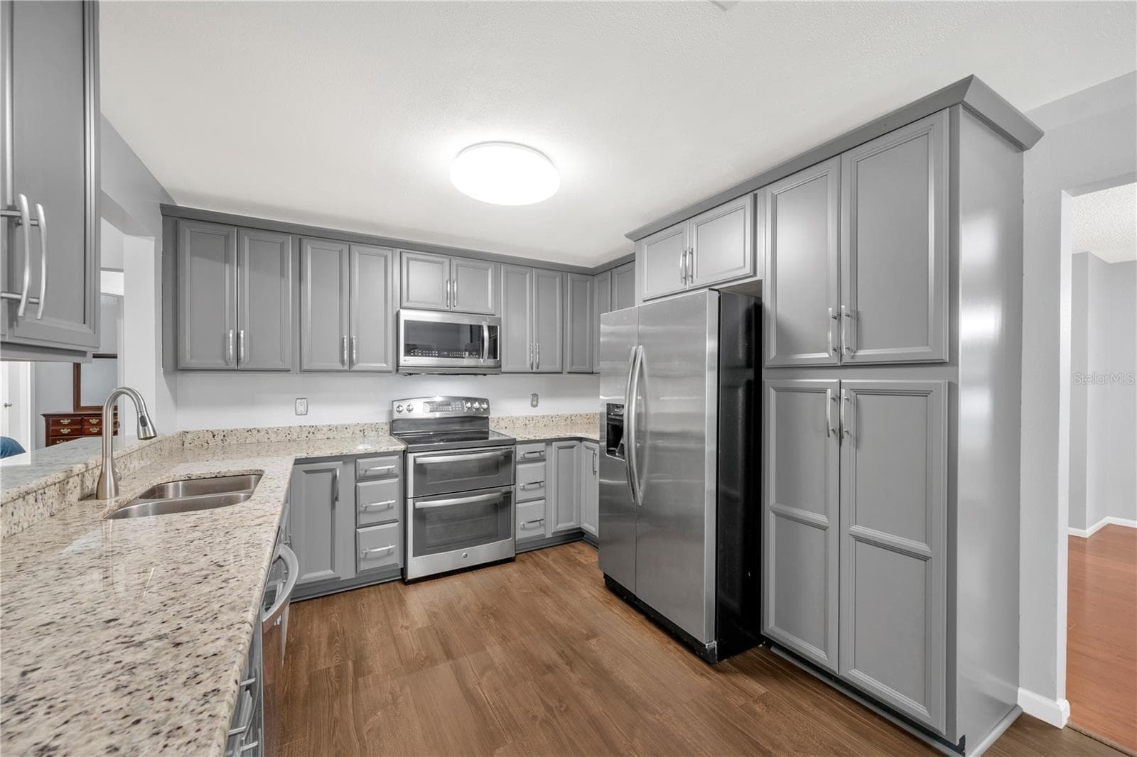 The recently remodeled kitchen features granite countertops and stainless steel appliances and flows easily into the main living areas. - 1418 SHELL FLOWER DR, BRANDON