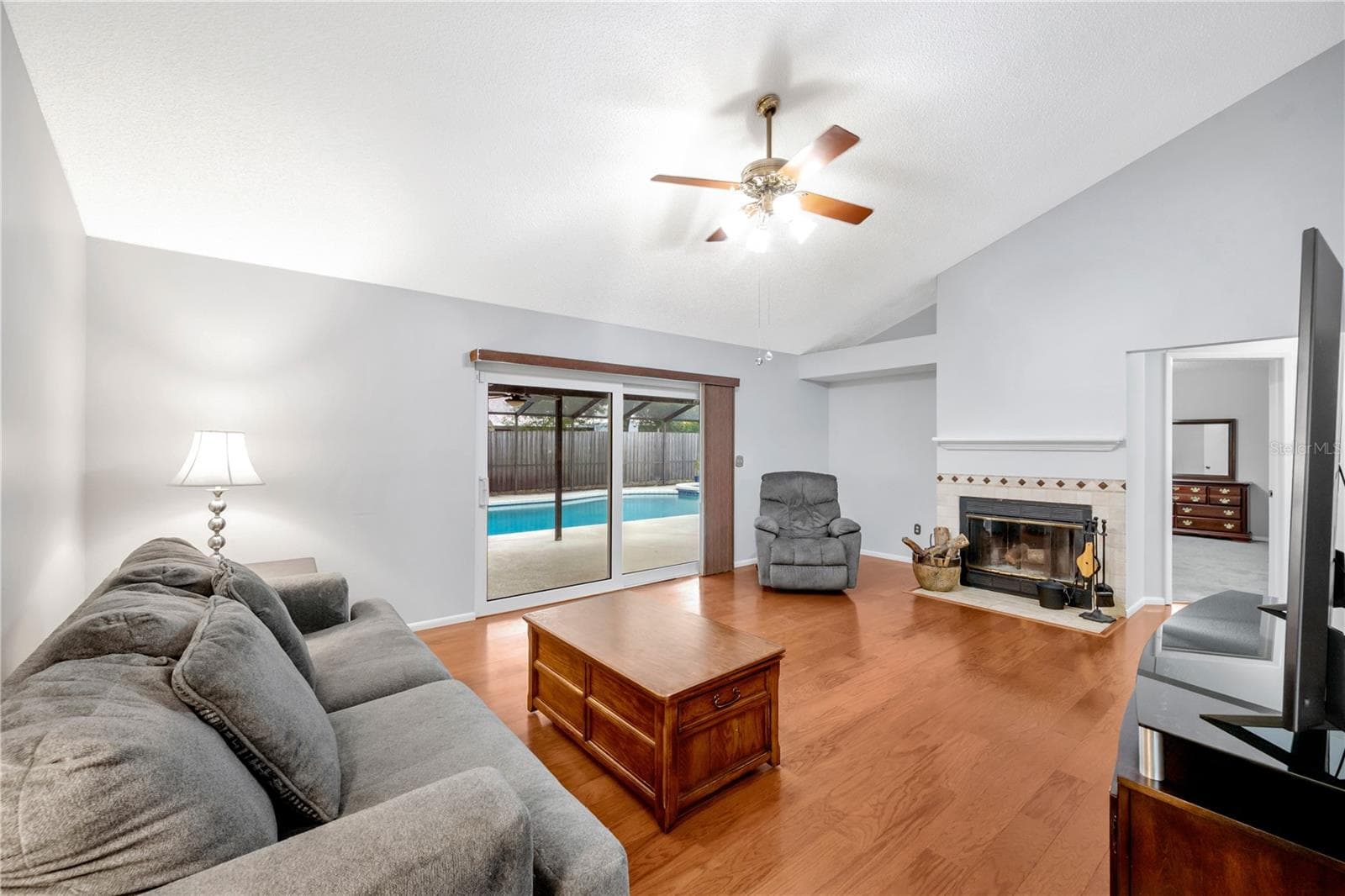 The inviting family room is filled with character, showcasing vaulted ceilings and a real wood-burning fireplace. - 1418 SHELL FLOWER DR, BRANDON