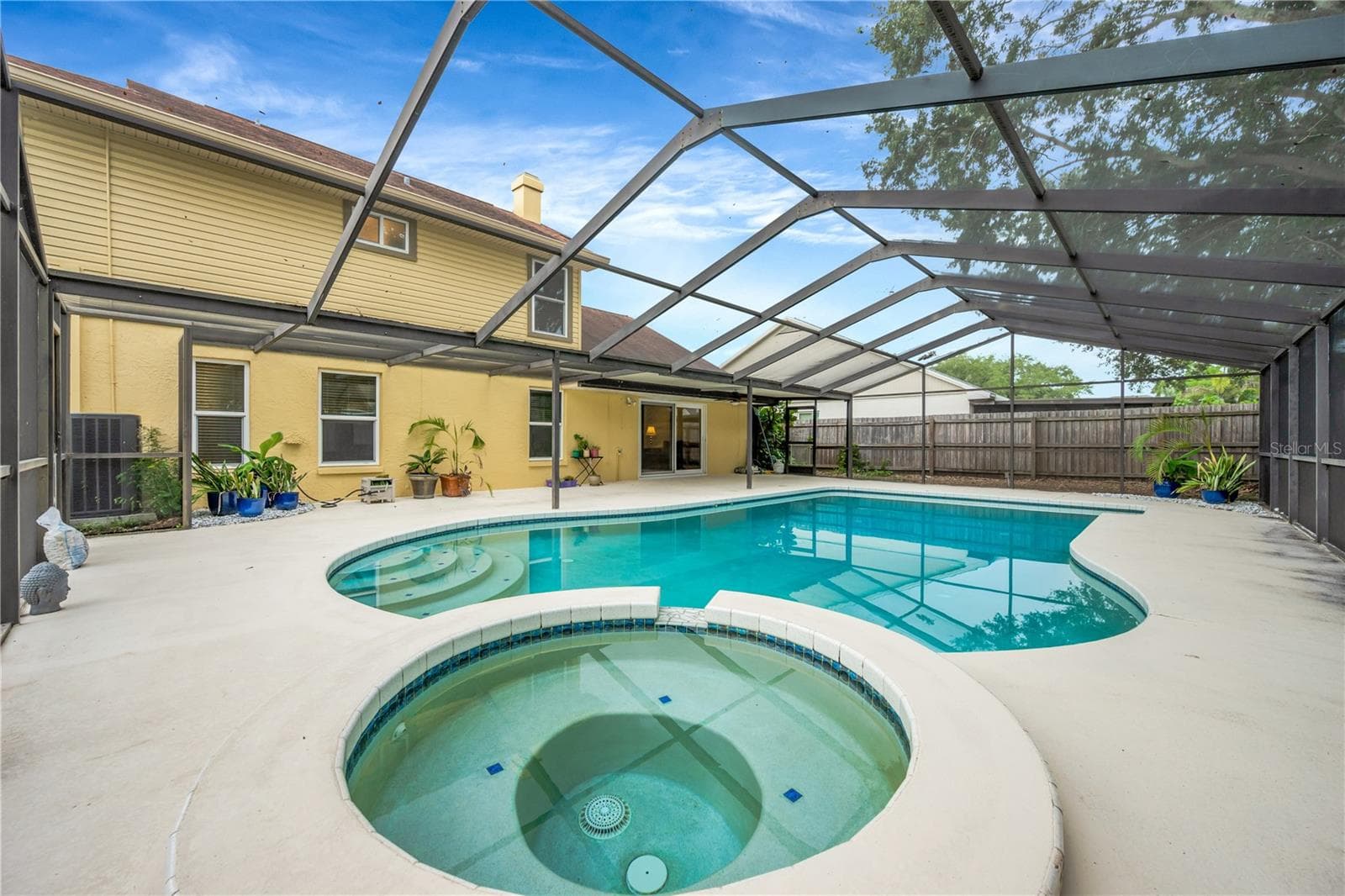 The backyard is sure to be a favorite gathering spot, featuring a deep, propane-heated pool and spa, all surrounded by a huge screened lanai. - 1418 SHELL FLOWER DR, BRANDON