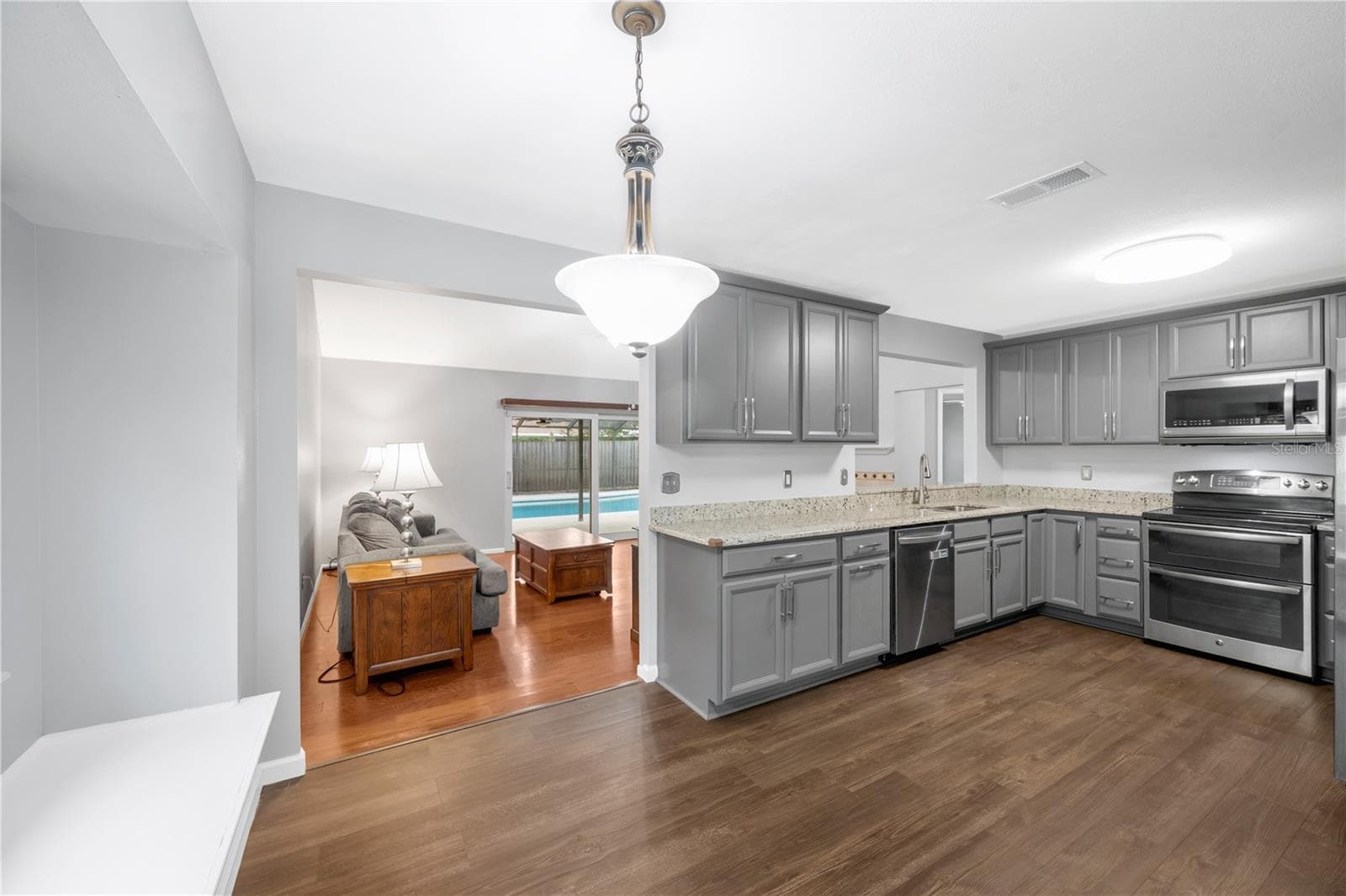 The kitchen was remodeled in 2023 with stylish cabinets, durable granite counters, stainless steel appliances and was designed with the perfect triangle work flow. - 1418 SHELL FLOWER DR, BRANDON