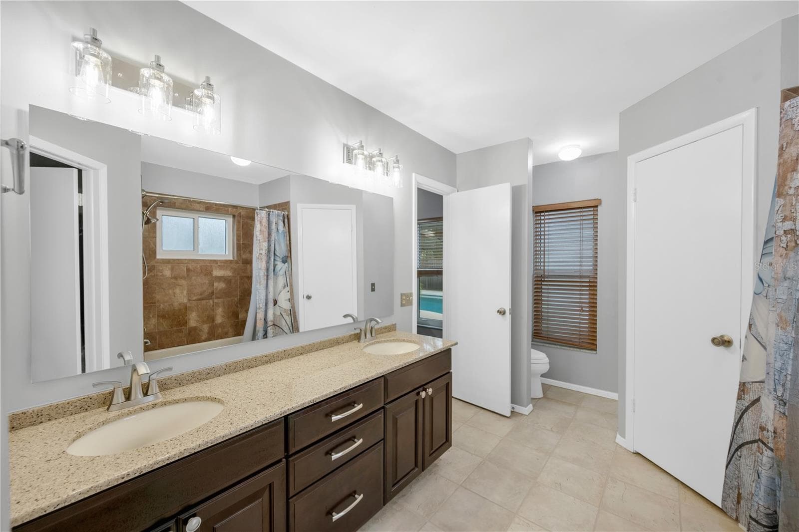 The Owner's ensuite has a large vanity with loads of storage and dual sinks on a granite counter. - 1418 SHELL FLOWER DR, BRANDON