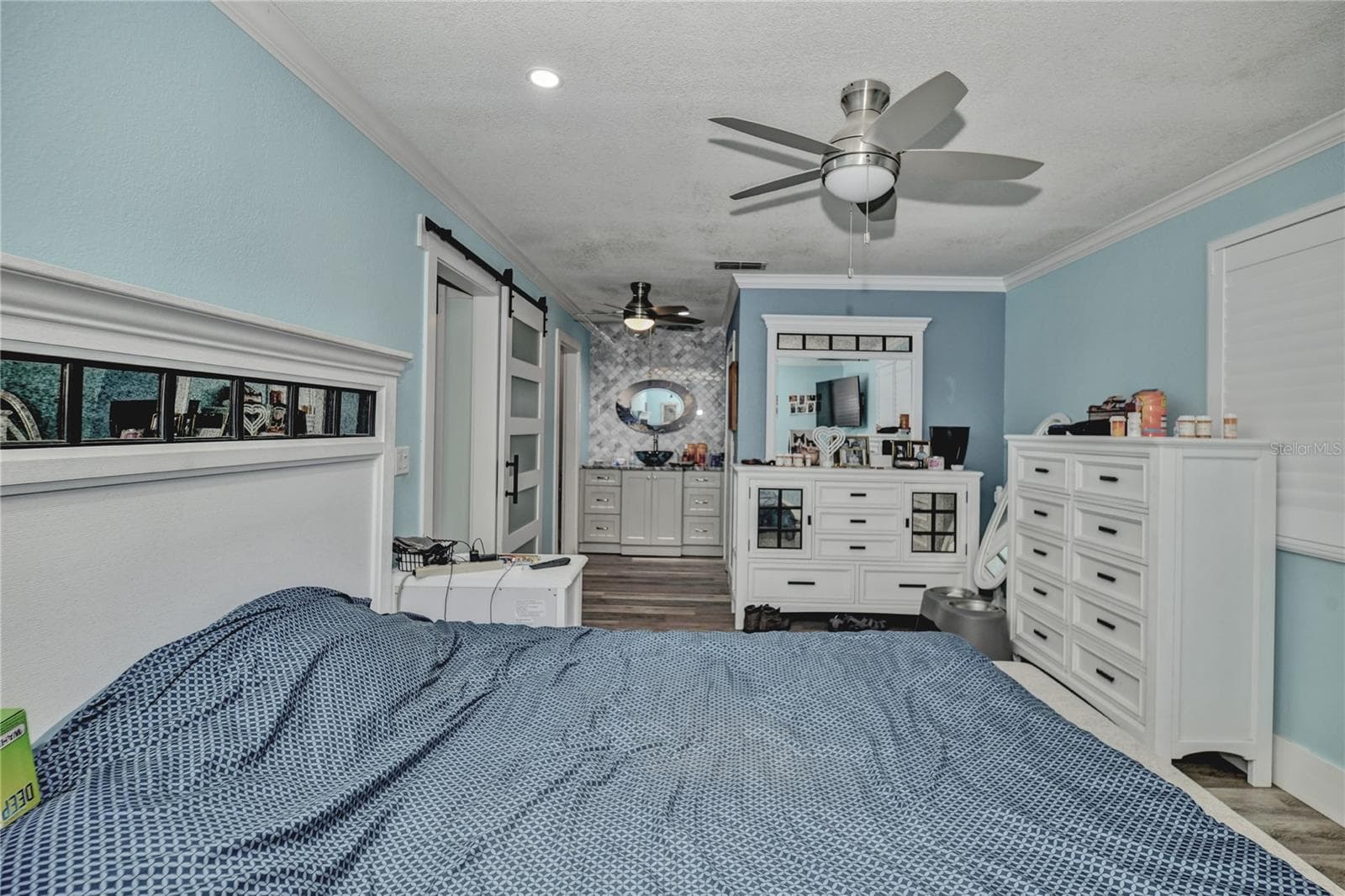 Primary bedroom barn door, high ceiling ceiling fan - 10958 SW 86TH CT, OCALA