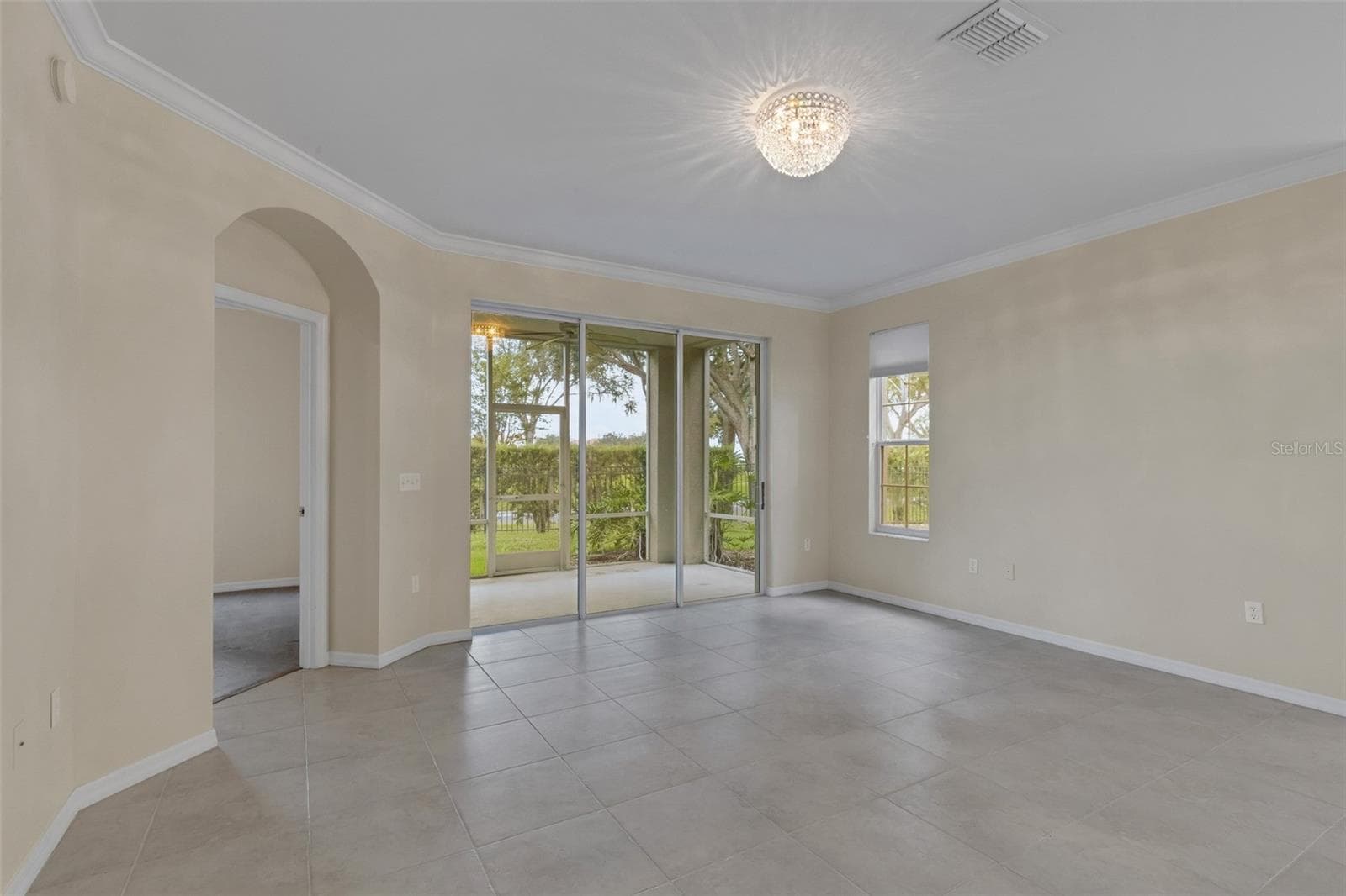 The arched doorway leads into the primary bedroom suite . . . - 684 GRASSLANDS VILLAGE CIR, LAKELAND