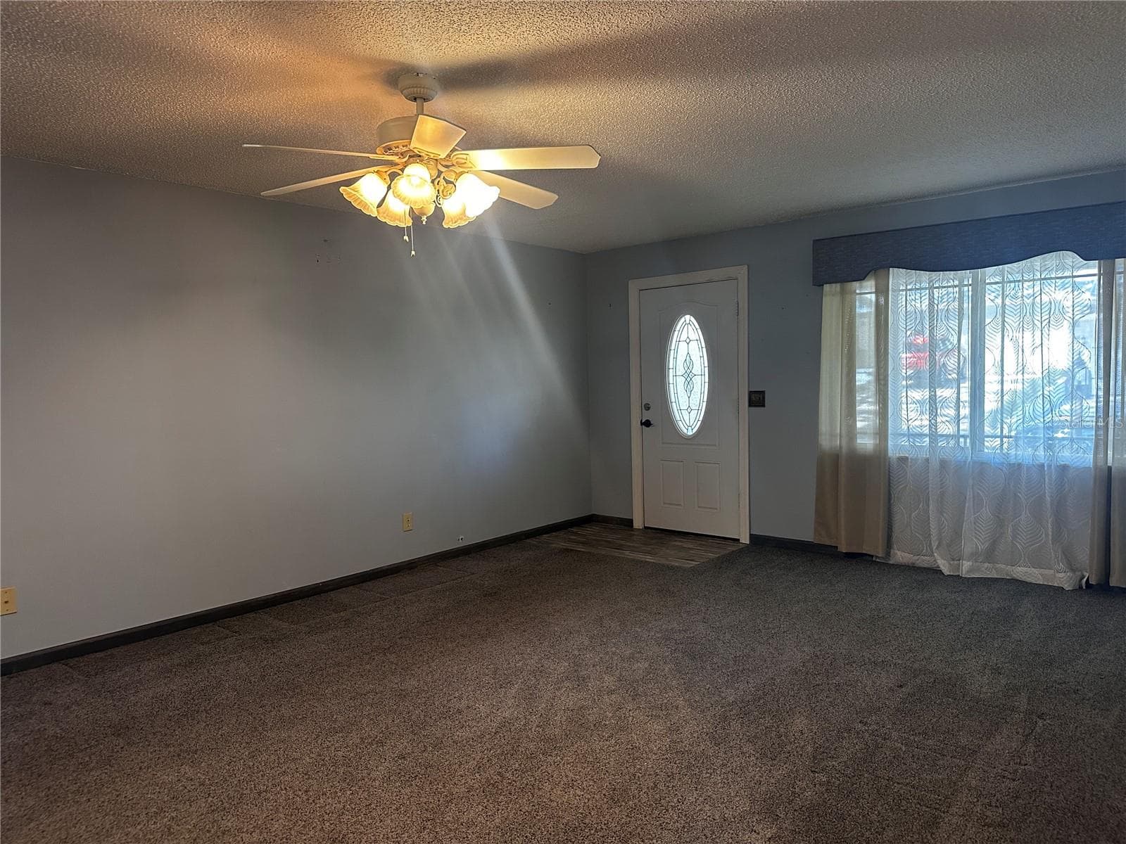 Living room with lovely newer front door and large windows - 8760 SW 98TH STREET RD #A, OCALA