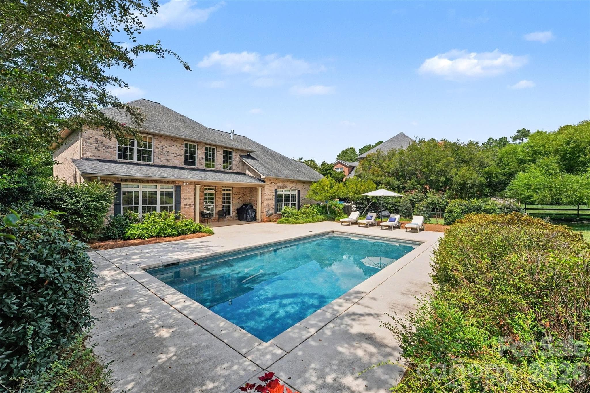 Step outside of your kitchen door onto the covered patio area and sit in the shade overlooking this gorgeous salt water pool. - 120 Palos Verde Drive, Mooresville