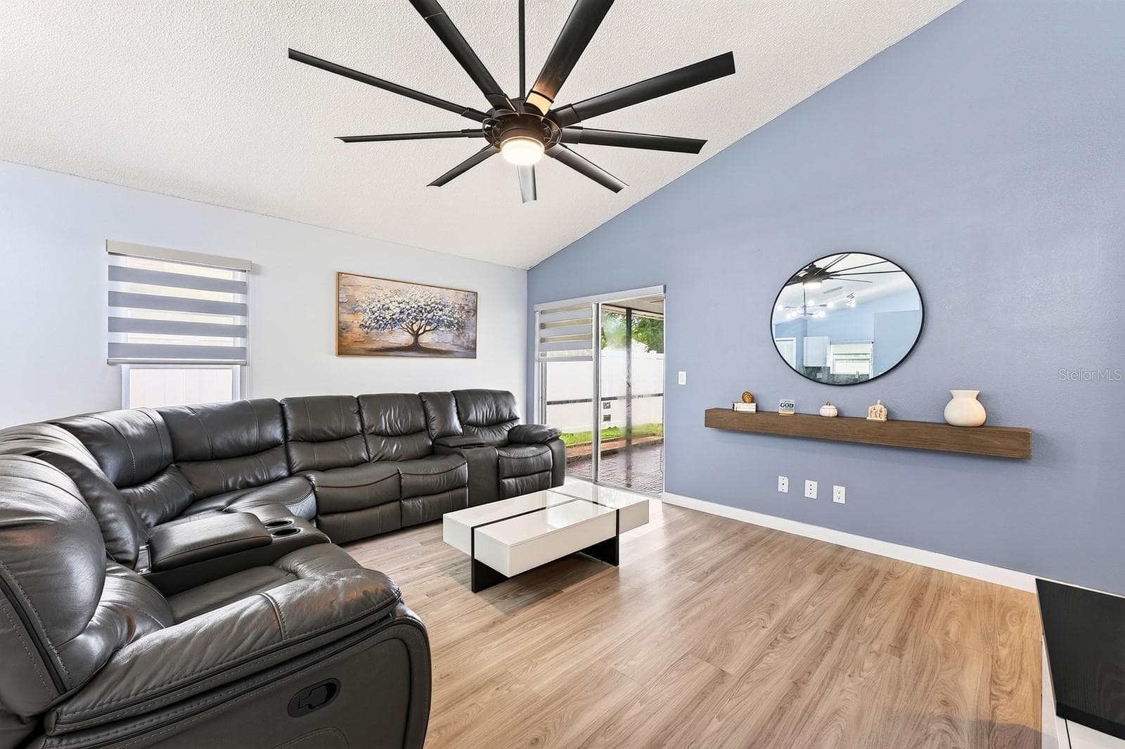 Living area has sliding glass doors that open to the covered lanai and screened pool. - 9905 DEAN ACRE DR, ORLANDO
