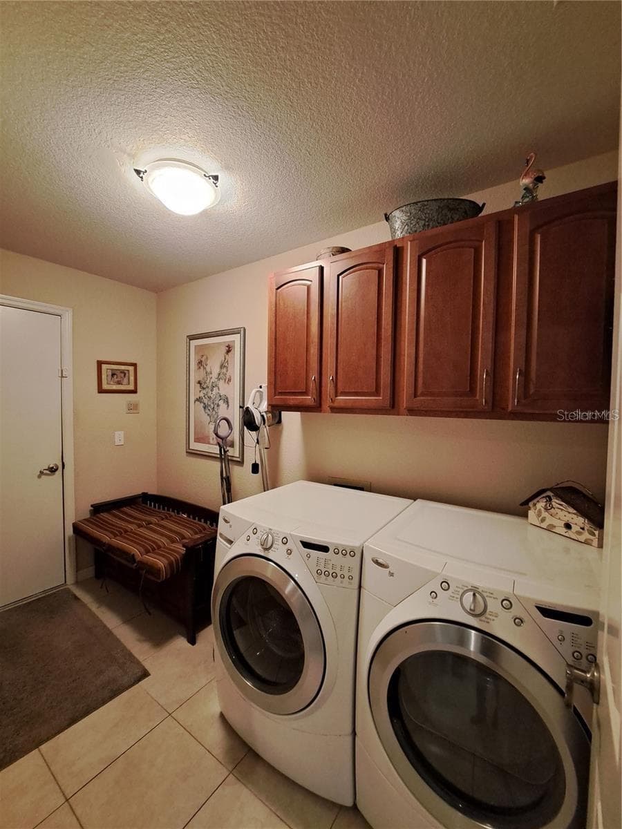 Laundry with extra space and wood cabinets and entry door to garage - 5316 LOCHMEAD TER, ZEPHYRHILLS