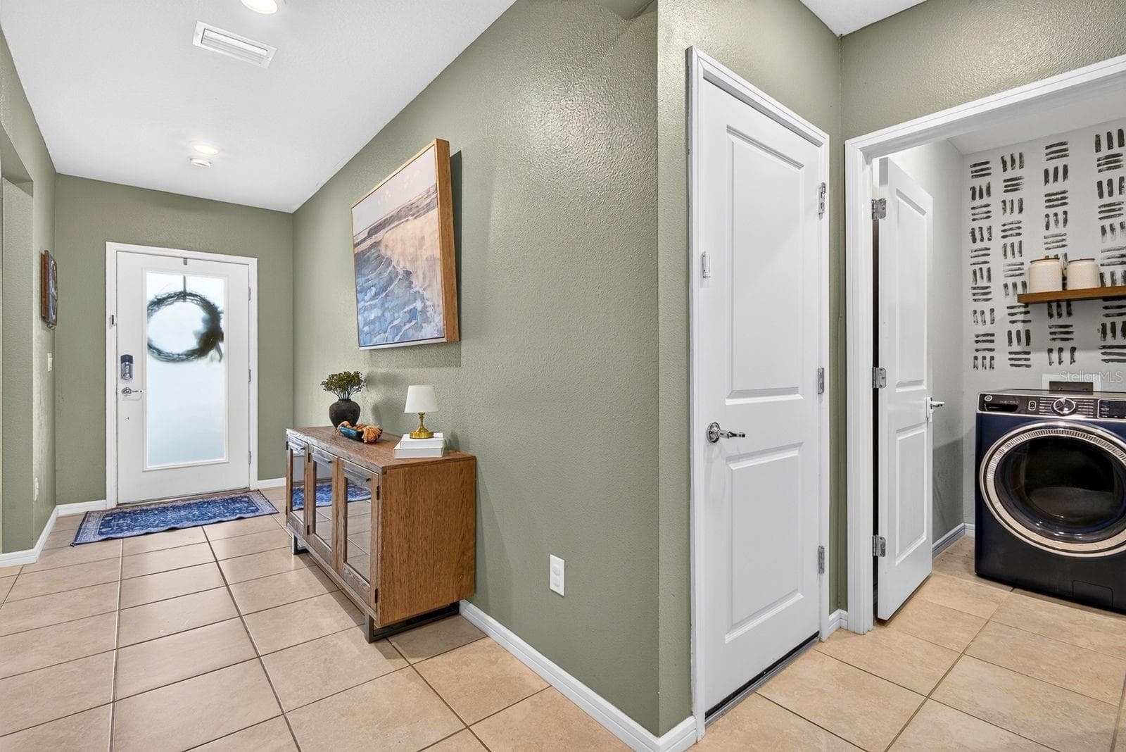 Hallway facing front showing laundry area to the right - 9348 ROYAL RIVER CIR, PARRISH