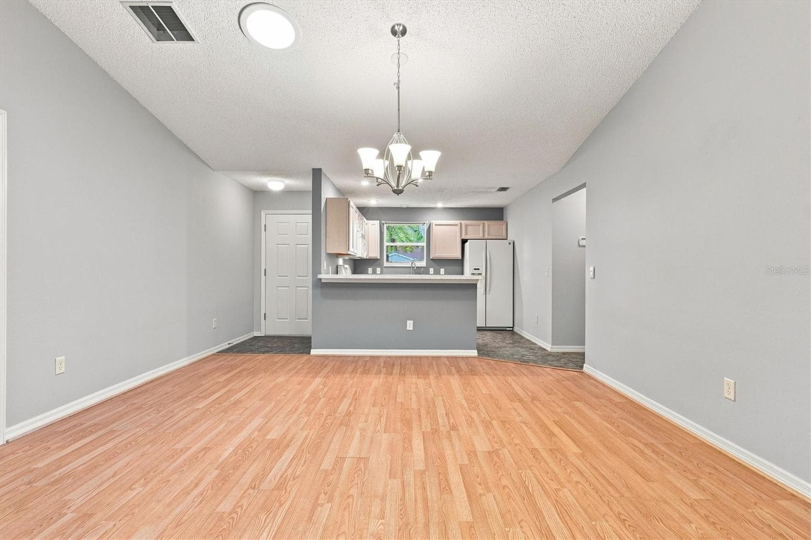 Living room: "Open living room with laminate flooring in The Villages Summerhill home" - 3565 IDLEWOOD LOOP, THE VILLAGES