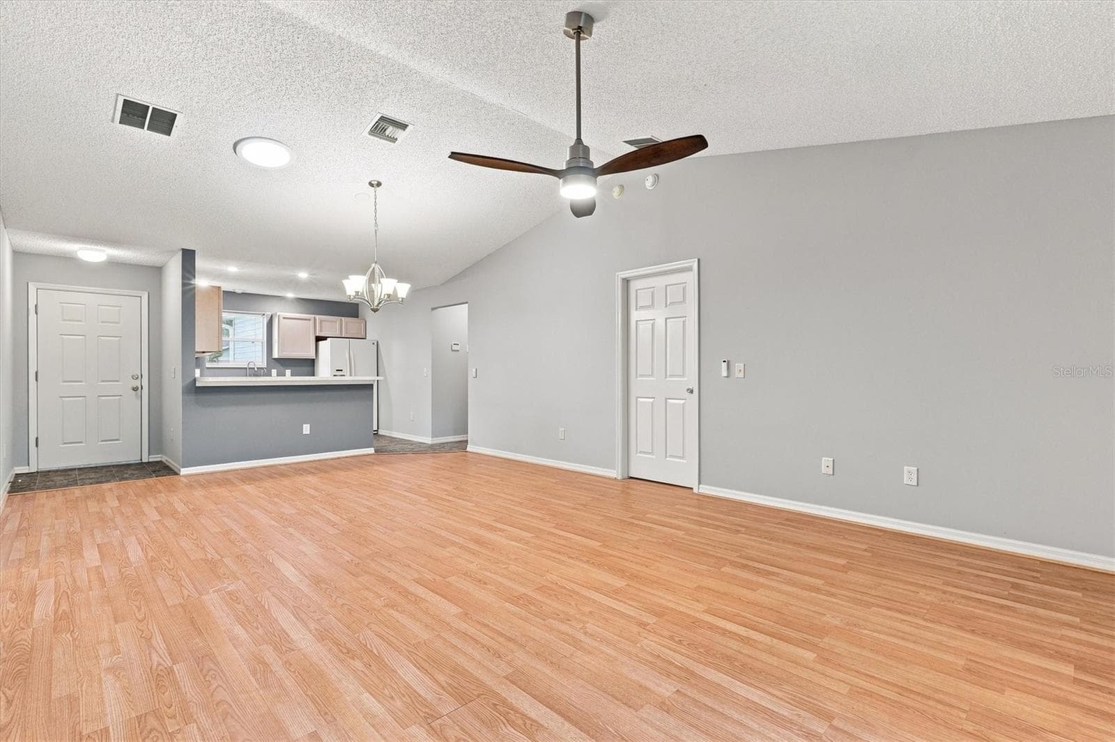Living room: "Open living room with laminate flooring in The Villages Summerhill home" - 3565 IDLEWOOD LOOP, THE VILLAGES