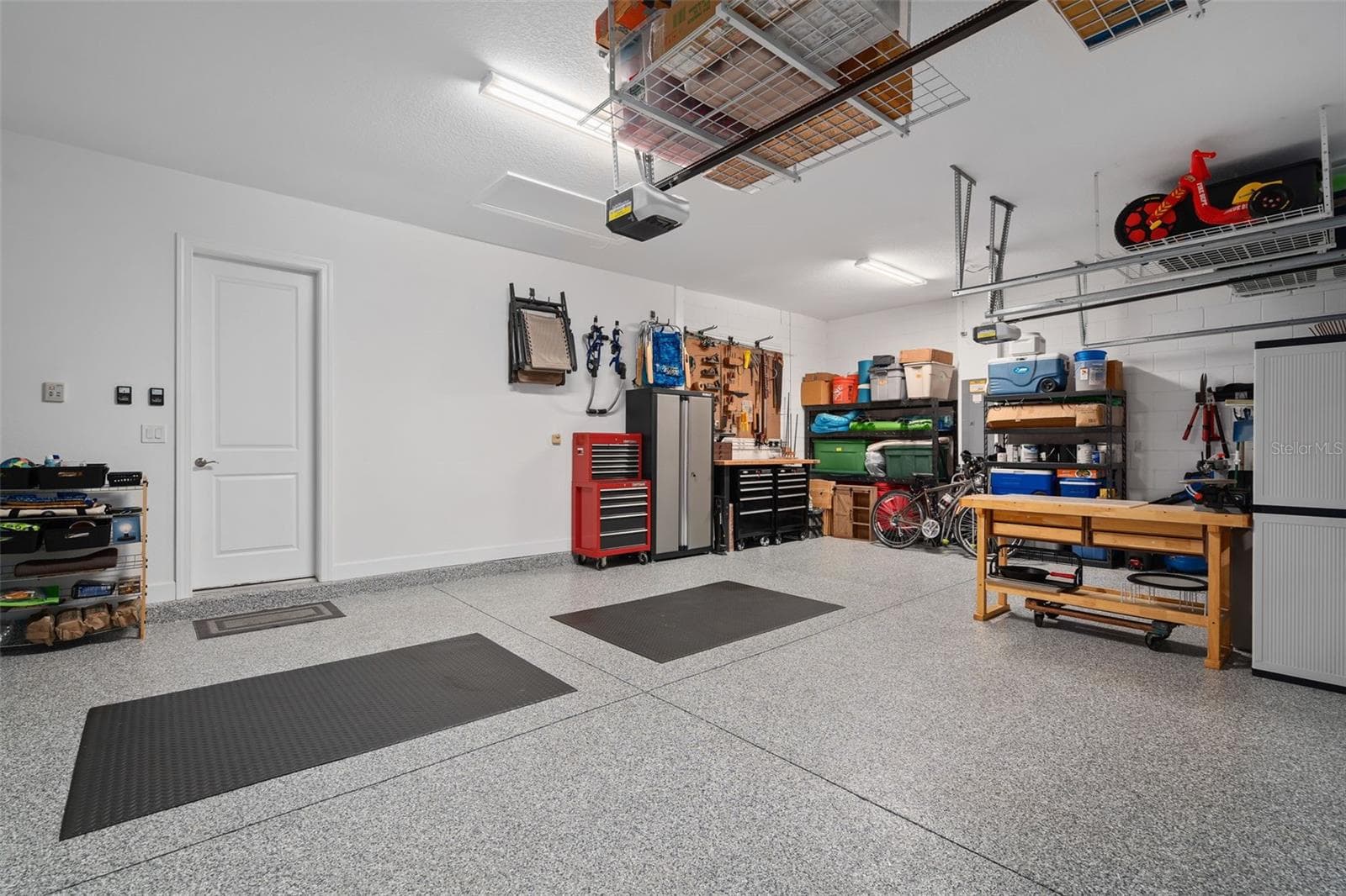 This full 3 car garage with a "Shark Coating" floor, Insulated garage doors and ceiling storage. - 1279 ZEEK RIDGE ST, CLERMONT