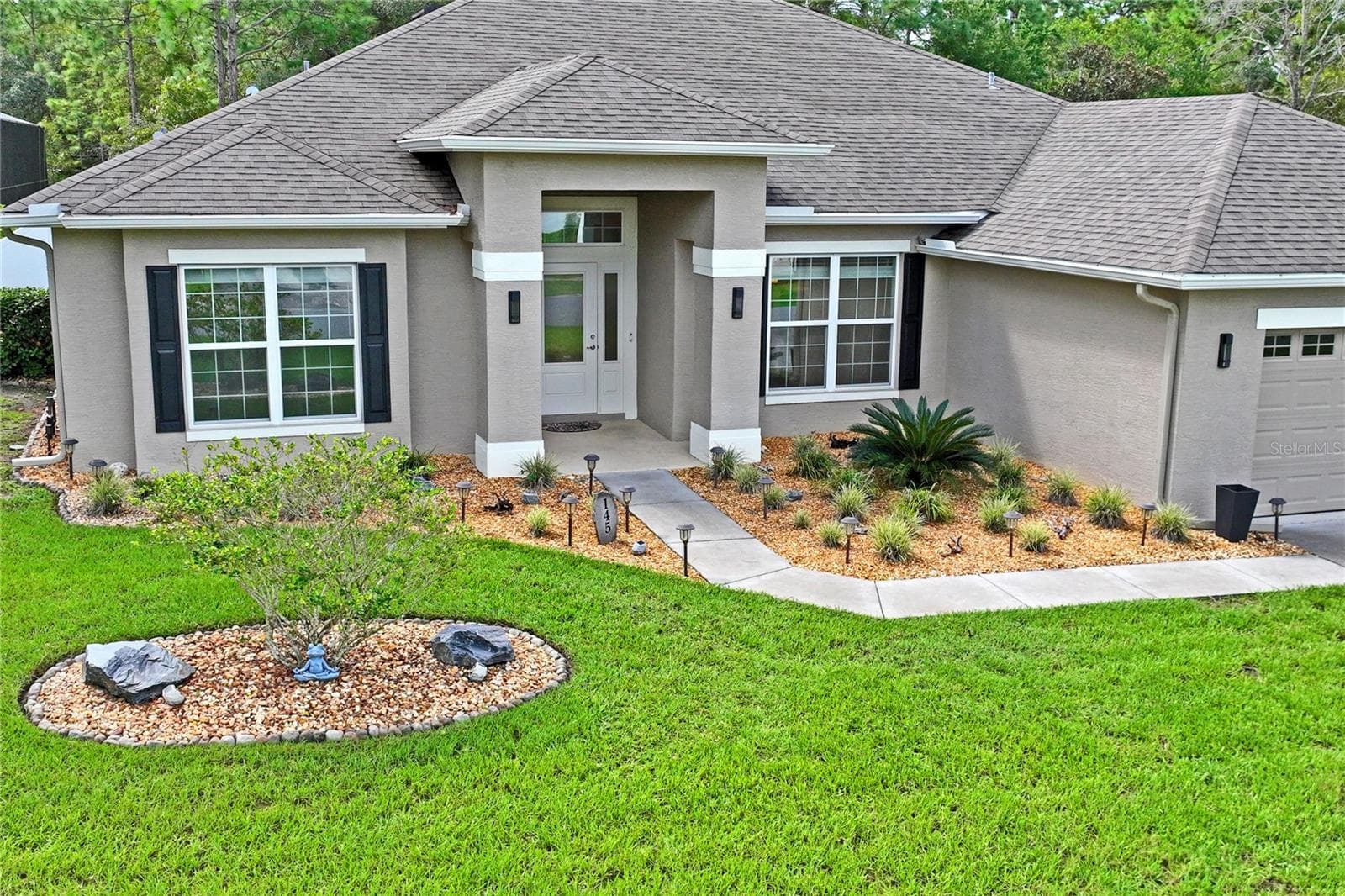 Landscaping package includes new front planter, tree, solar lighting, lighted house number, large rocks and beds with rocks all around house!! - 145 LINDER DR, HOMOSASSA