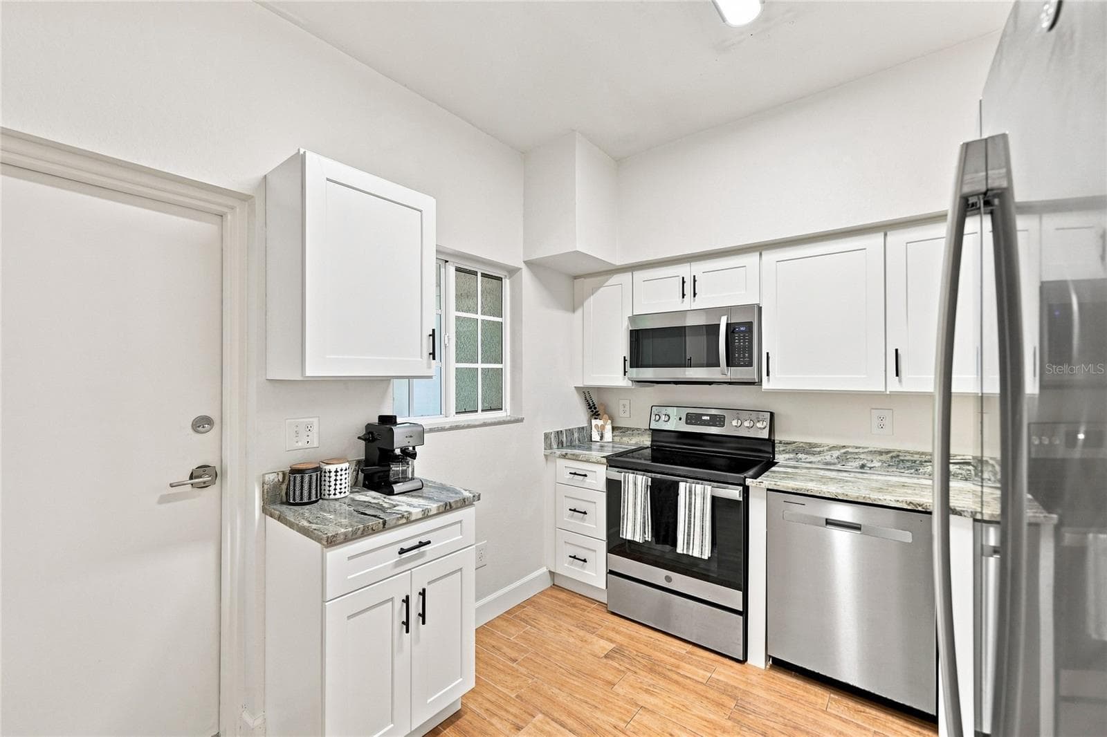 Kitchen with window for natural light and entry to screened lanai - 8423 BERNWOOD COVE LOOP #410, FORT MYERS