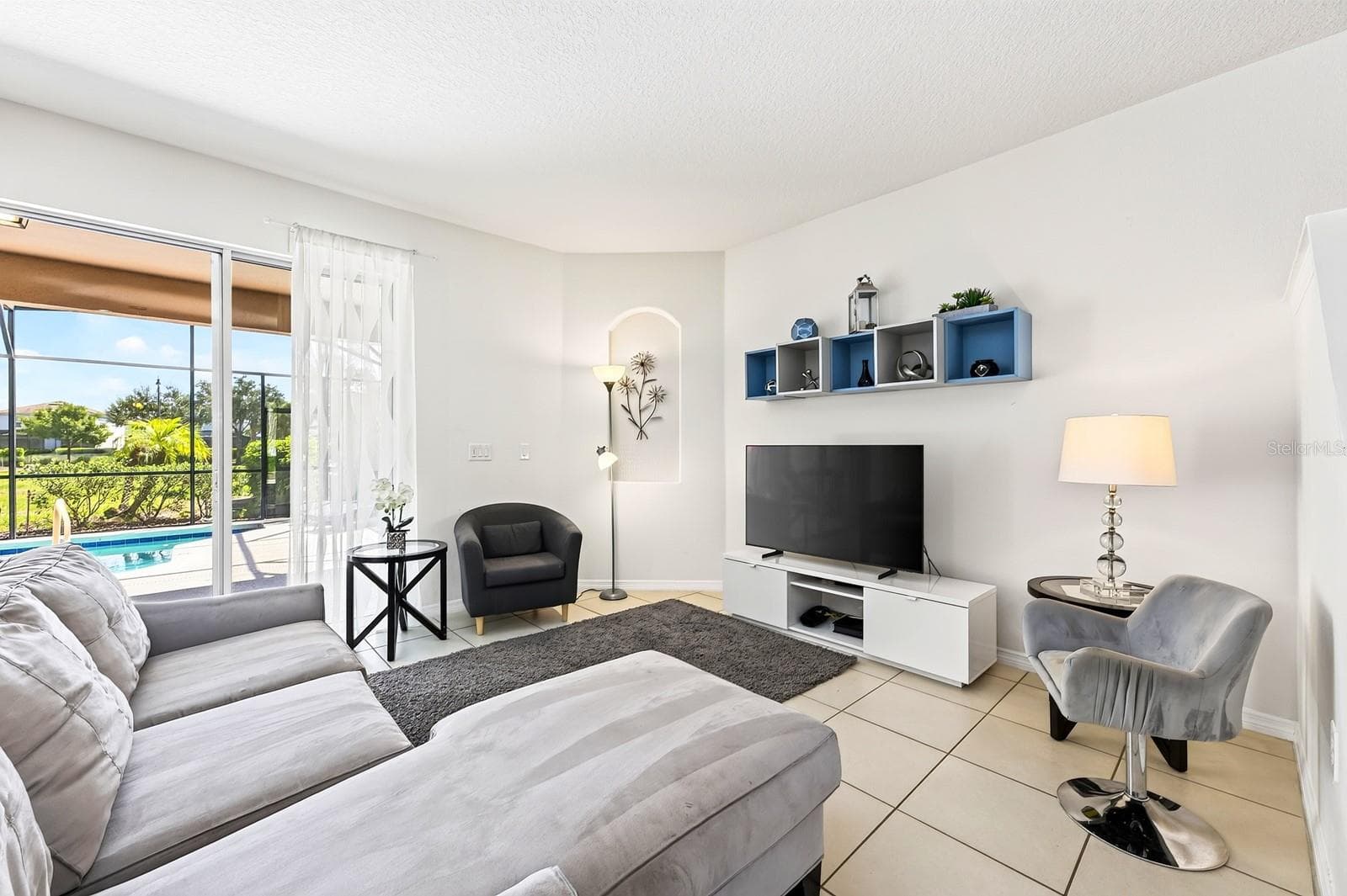 Abundant NATURAL LIGHT and EASY-CARE TILE FLOORING create a welcoming atmosphere in the Living Room. - 4722 TERRASONESTA DR, DAVENPORT
