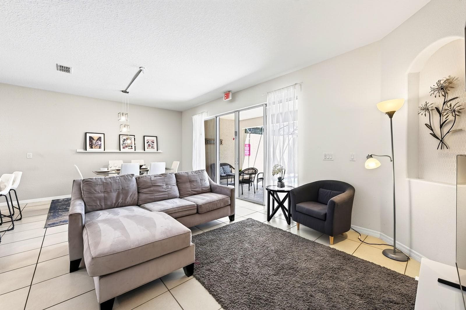 Abundant NATURAL LIGHT and EASY-CARE TILE FLOORING create a welcoming atmosphere in the Living Room. - 4722 TERRASONESTA DR, DAVENPORT