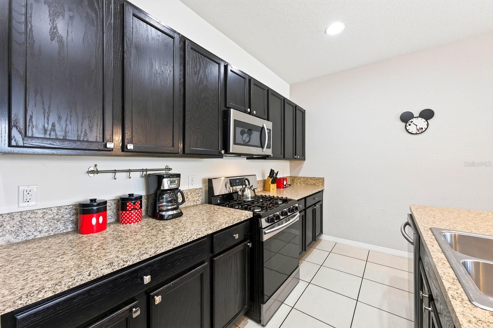 The well-appointed Kitchen features plenty of cabinet and counter space, a large ISLAND WITH BREAKFAST BAR SEATING and STAINLESS STEEL APPLIANCES, including a GAS STOVE. - 4722 TERRASONESTA DR, DAVENPORT