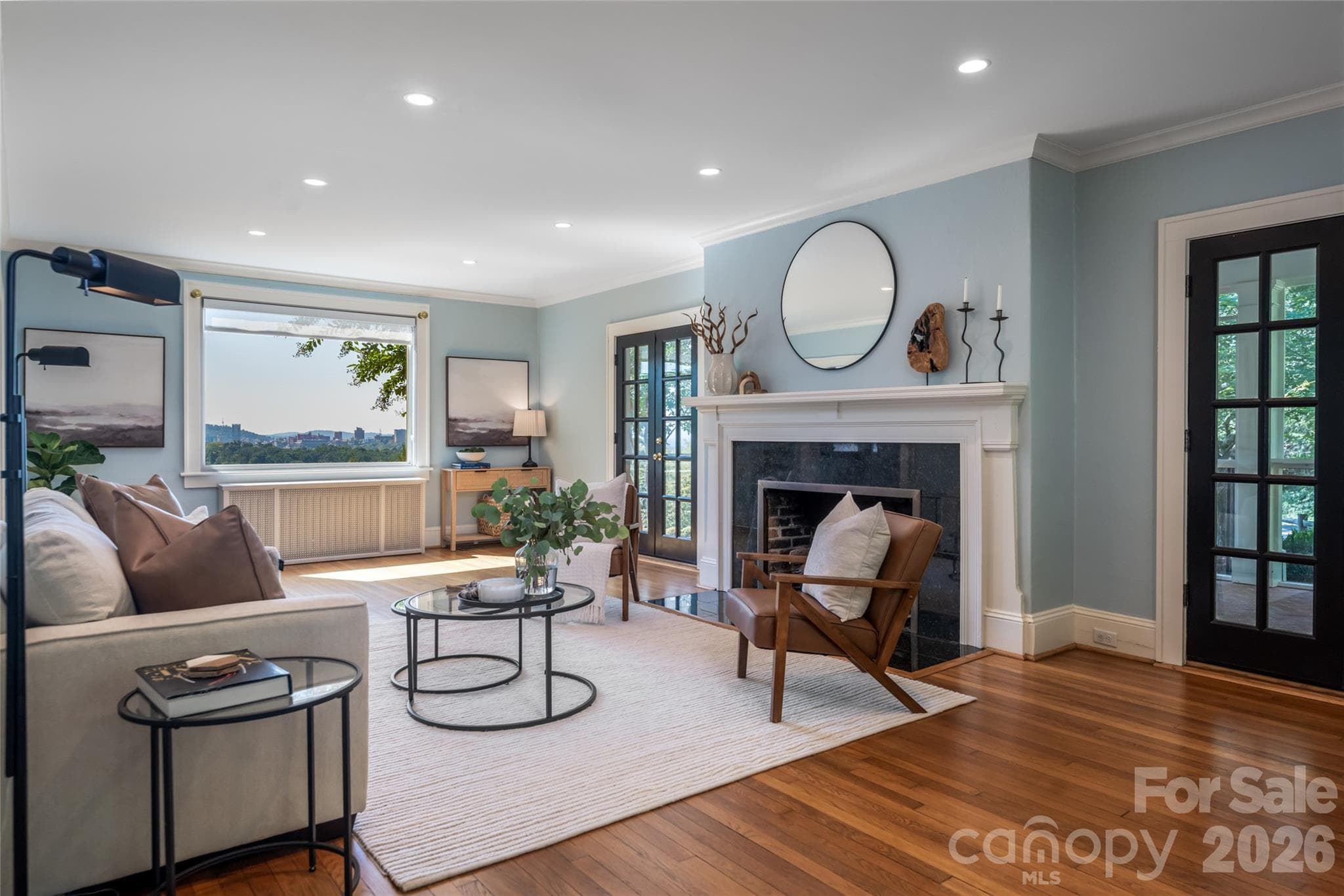 The living room not only has stunning views of downtown Asheville but a large gas fireplace and direct access to the screened in porch. - 35 Elias Place, Asheville