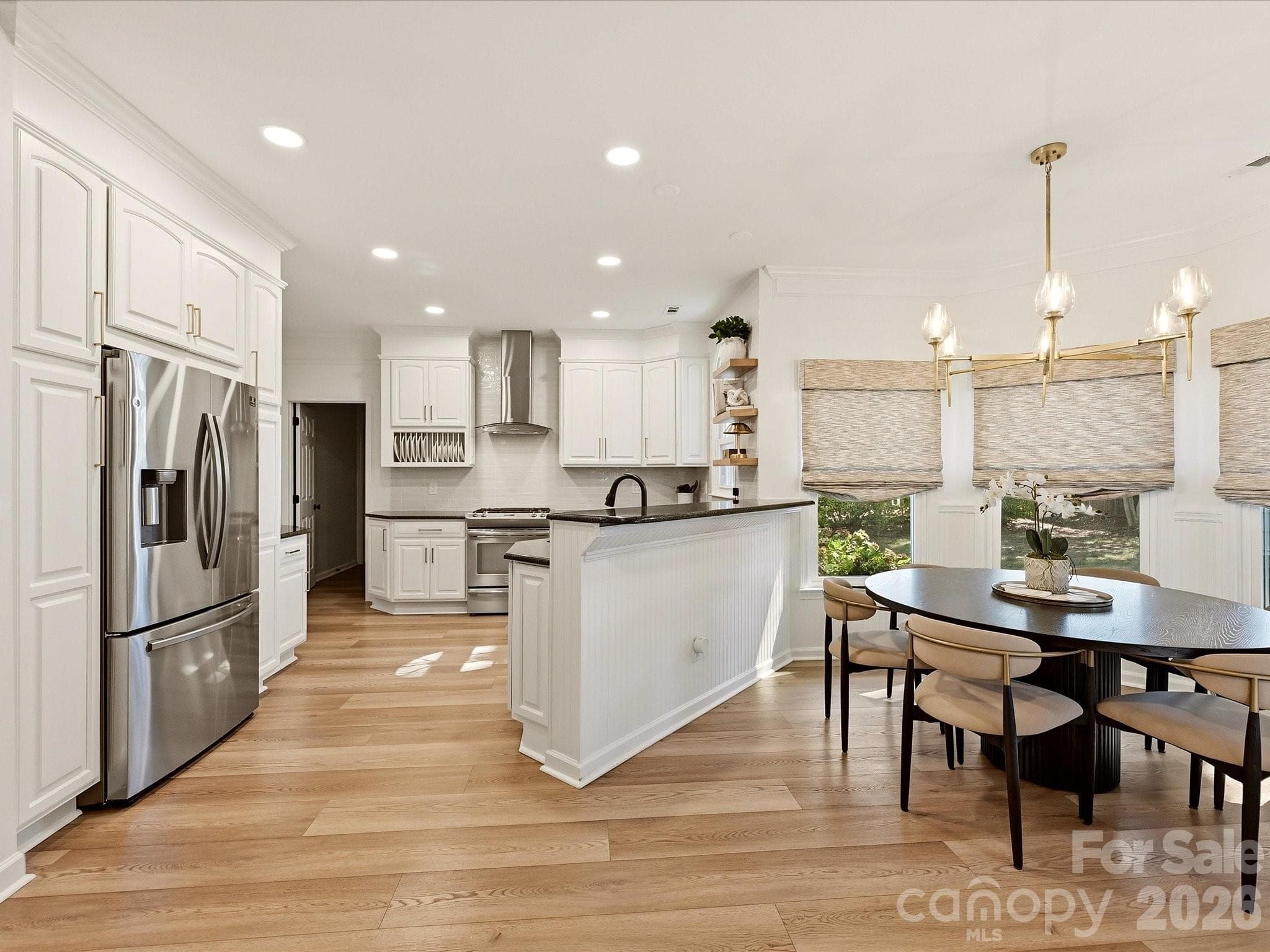 Updated kitchen features a spacious peninsula with breakfast bar seating, abundant cabinetry, modern finishes, and an open layout overlooking the living area. - 19706 Valiant Way, Cornelius
