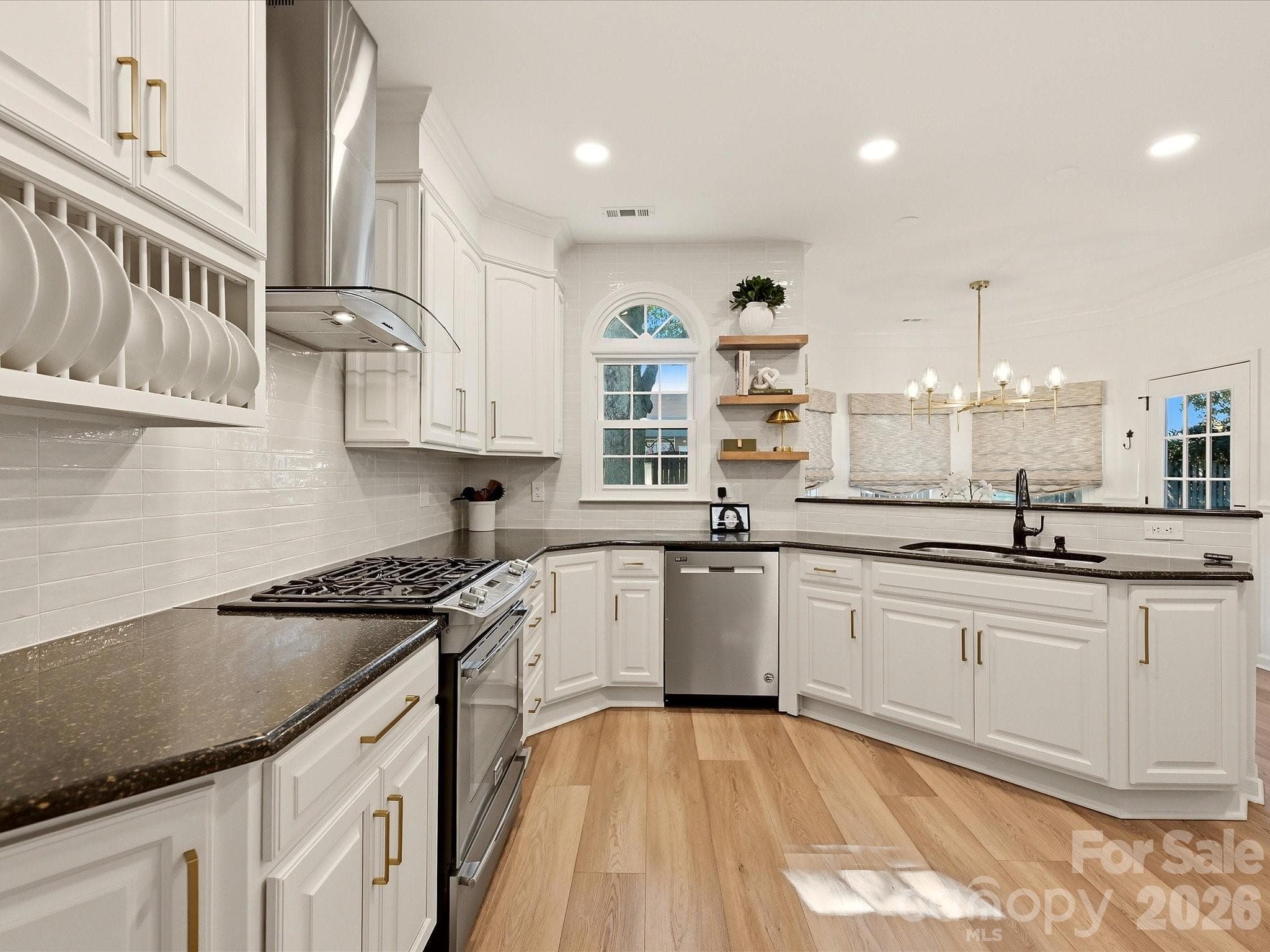 Updated kitchen showcases crisp cabinetry, tile backsplash, generous workspace, and a peninsula with breakfast bar seating ideal for casual dining and entertaining. - 19706 Valiant Way, Cornelius