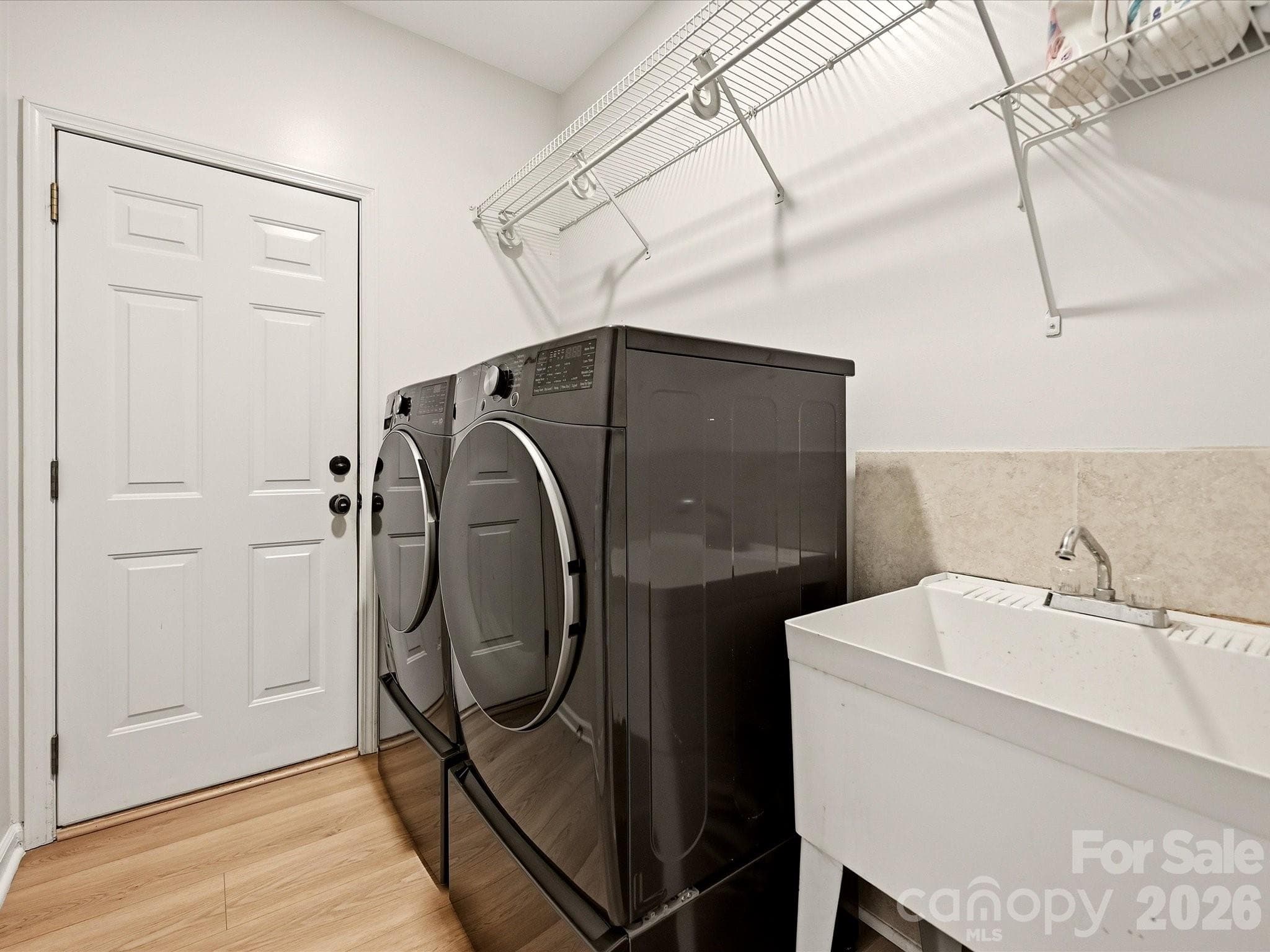 Convenient main-level laundry and mudroom offers a utility sink, storage, and direct access near the garage. - 19706 Valiant Way, Cornelius