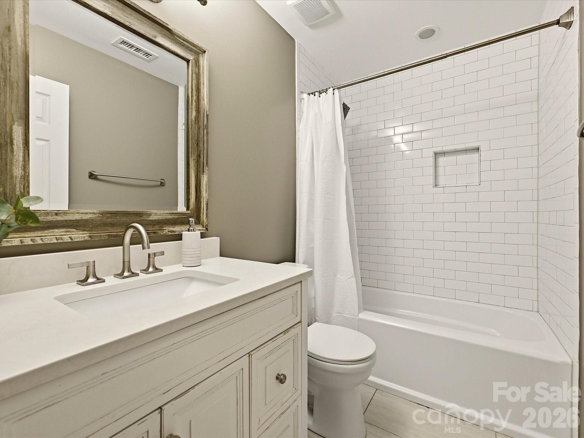 Upstairs full bathroom features an updated vanity and tub-shower combination with clean, neutral finishes. - 19706 Valiant Way, Cornelius