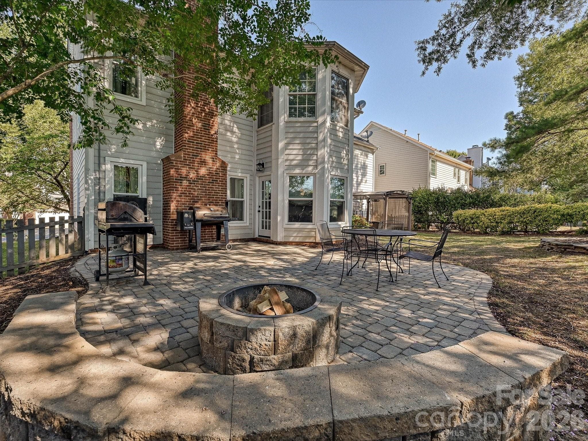 Fenced backyard features a spacious patio and built-in firepit, perfect for outdoor gatherings and relaxing evenings. - 19706 Valiant Way, Cornelius