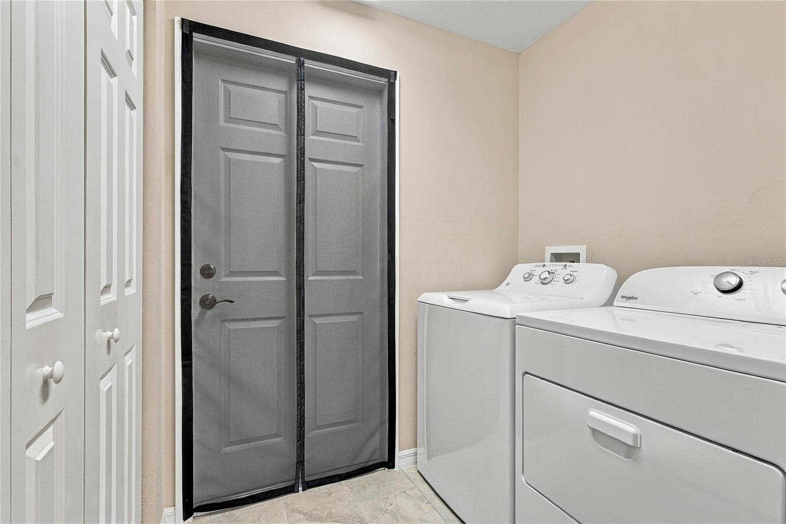 INDOOR LAUNDRY ROOM WITH TILE AND STORAGE CLOSET. WASHER AND DRYER INLCUDED! - 10554 LIVE OAK RD, PORT CHARLOTTE