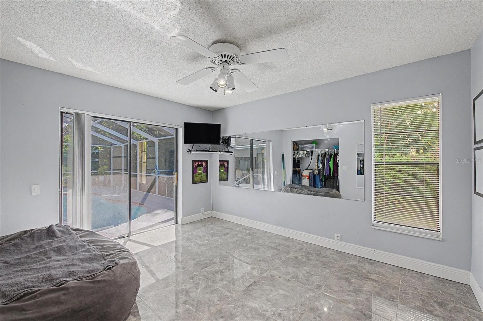 Bedroom 2 with slider doors to pool. - 8612 BRAXTON DR, HUDSON