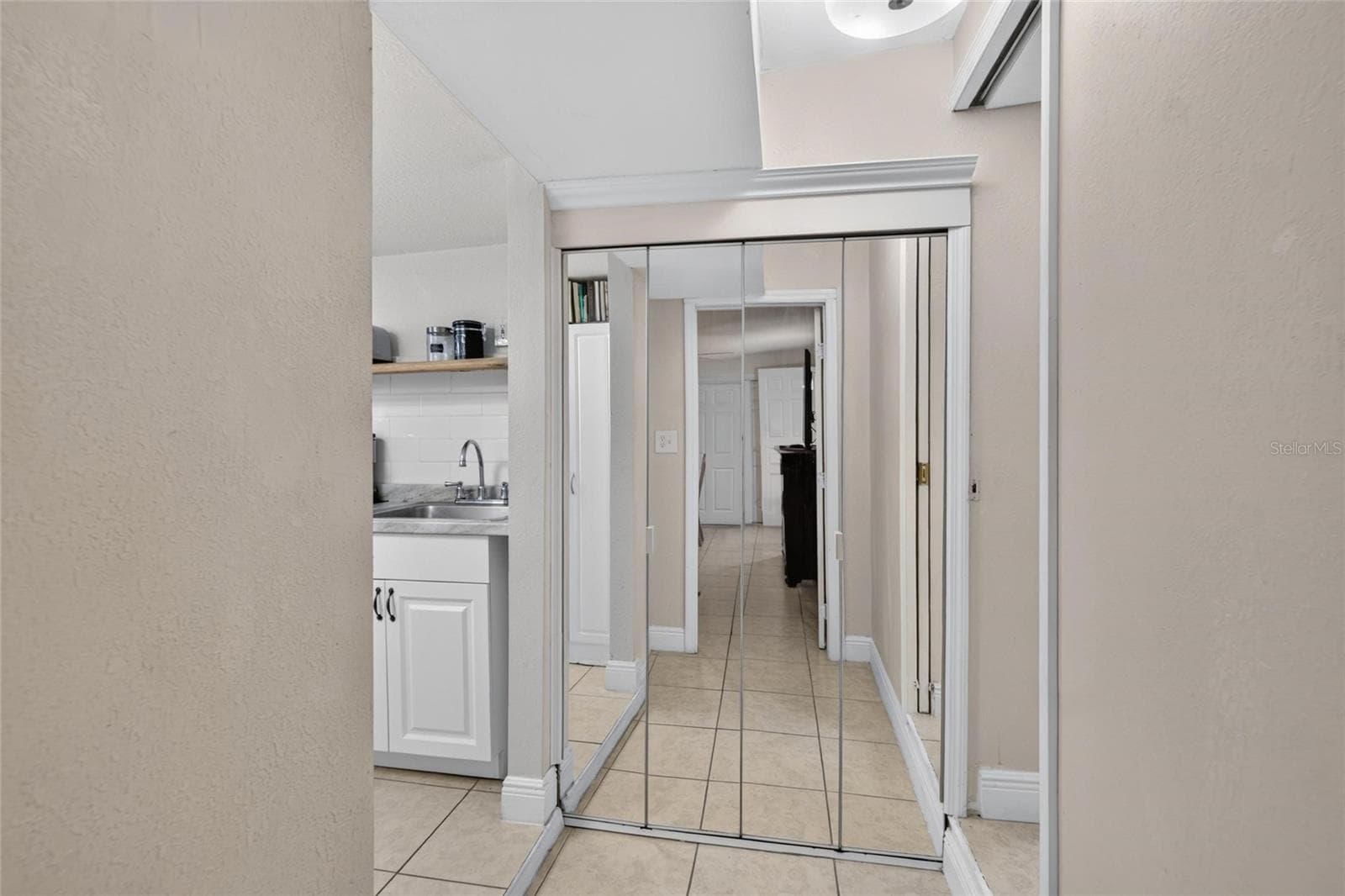Hallway connecting Bedroom Three to the Kitchenette on the left and a bathroom on the right. - 1727 WAIKIKI WAY, TAMPA