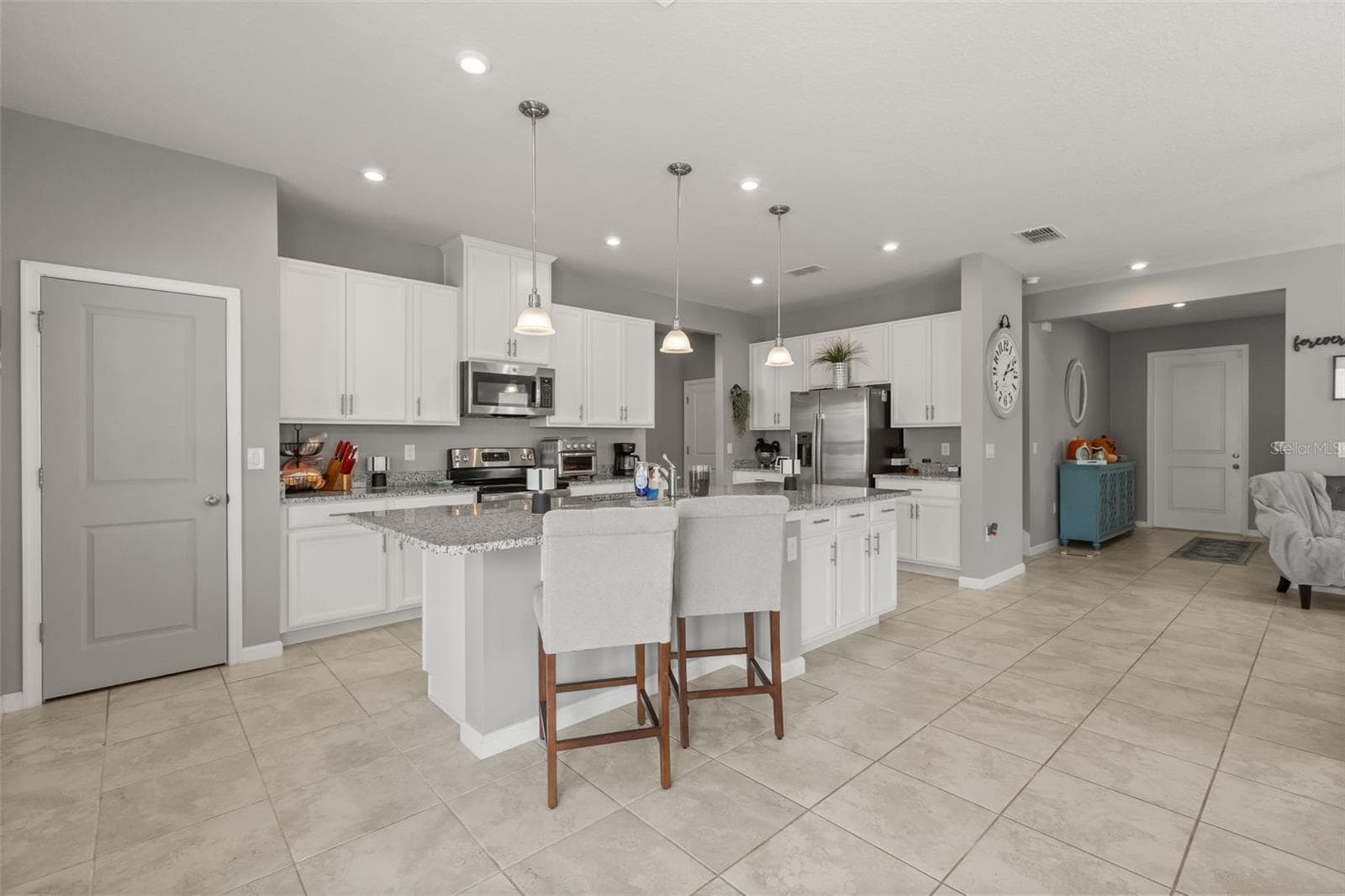Kitchen area with large granite service island, drop & recessed lighting, and pantry closet - 1596 EUCALYPTUS WAY, DAVENPORT
