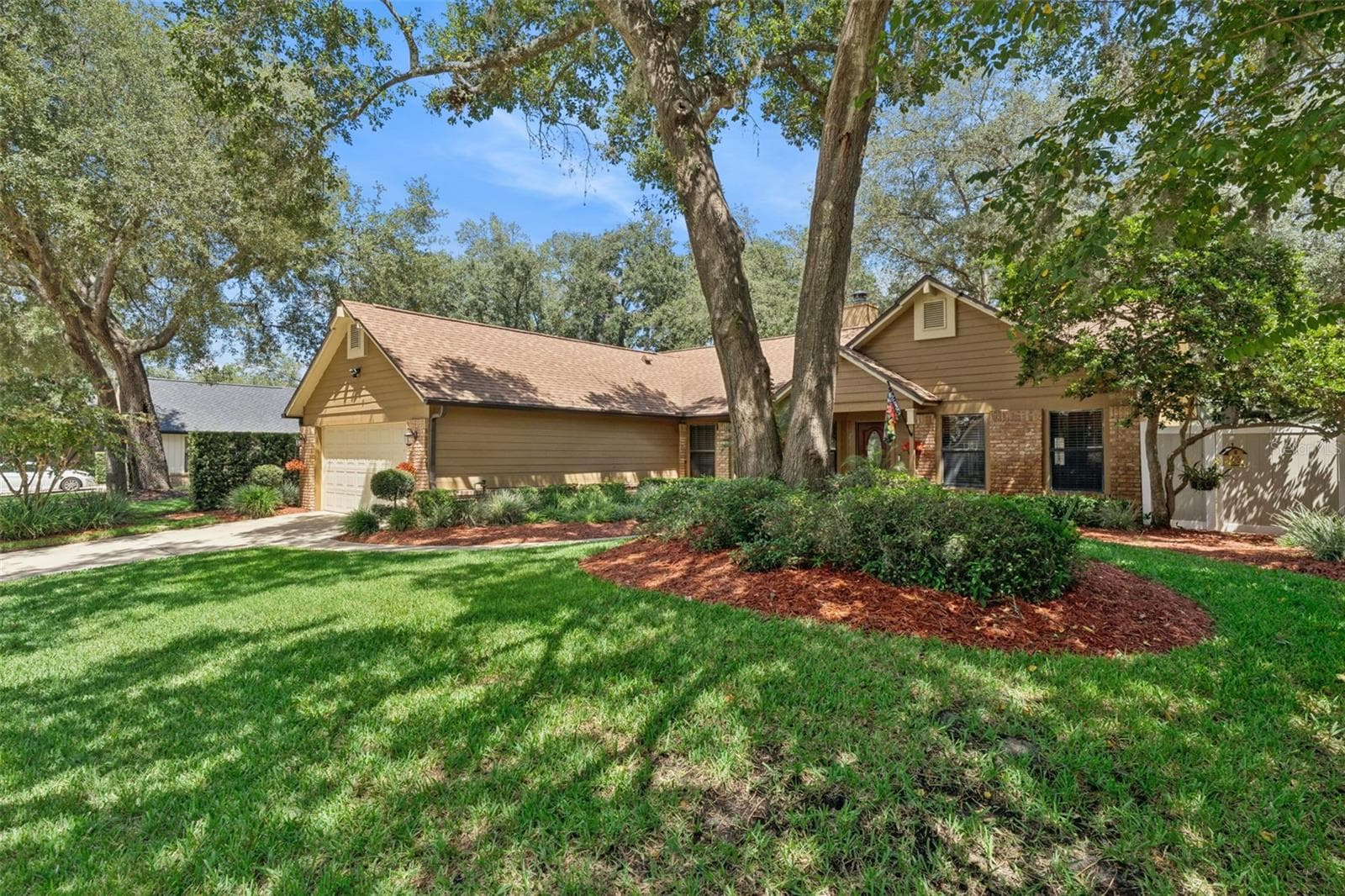 Beautiful street view showcasing the spacious front yard, mature oaks and lush landscaping. - 288 RINGWOOD DR, WINTER SPRINGS