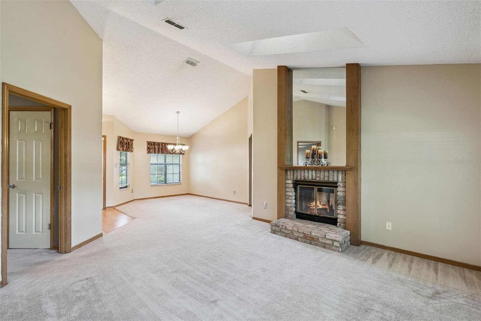 Spacious living and dining areas with soaring vaulted ceilings, skylights and a double-sided brick fireplace. - 288 RINGWOOD DR, WINTER SPRINGS