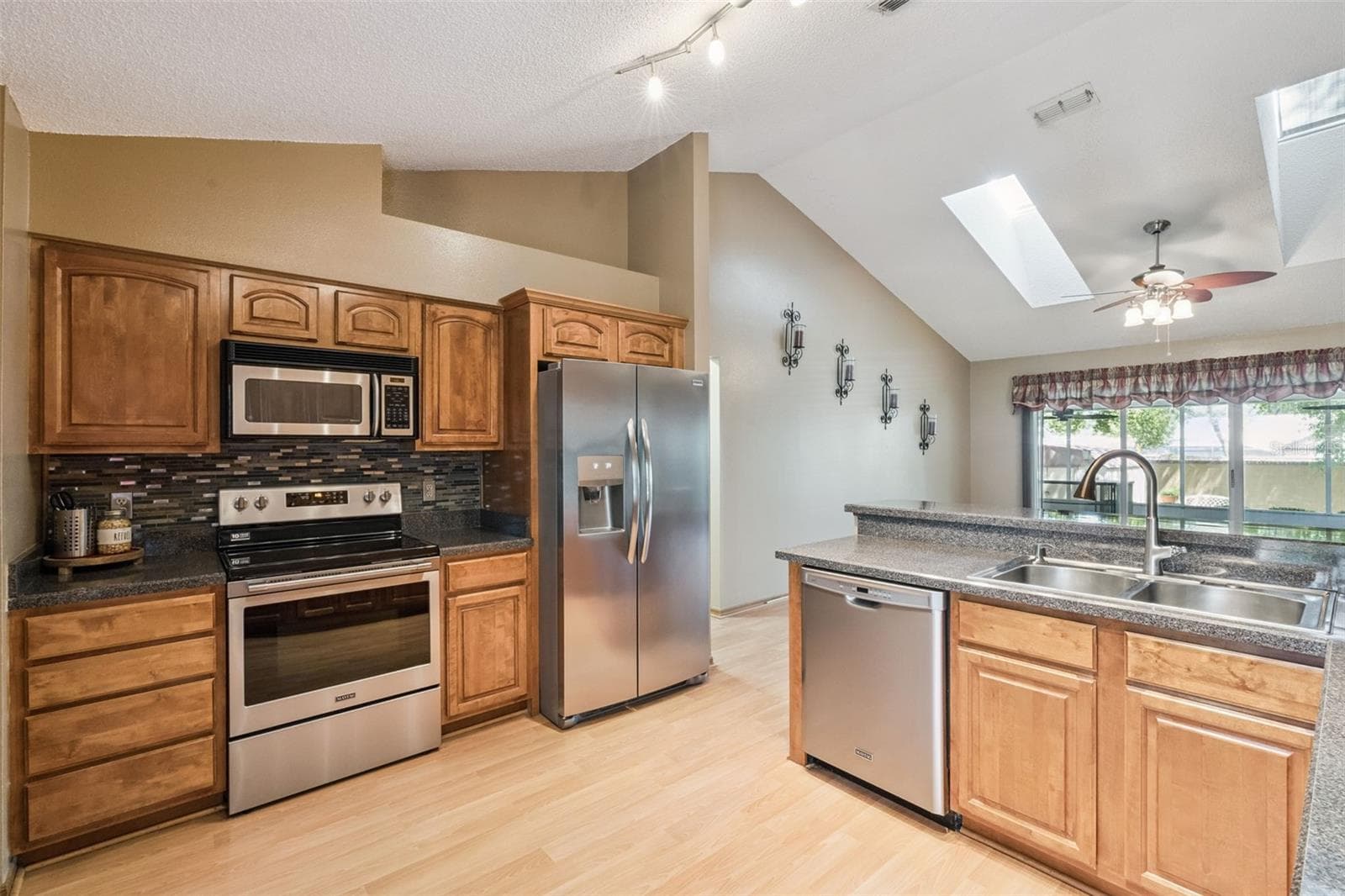 Updated kitchen featuring stainless-steel appliances, tiled backsplash and beautiful solid wood cabinetry. - 288 RINGWOOD DR, WINTER SPRINGS