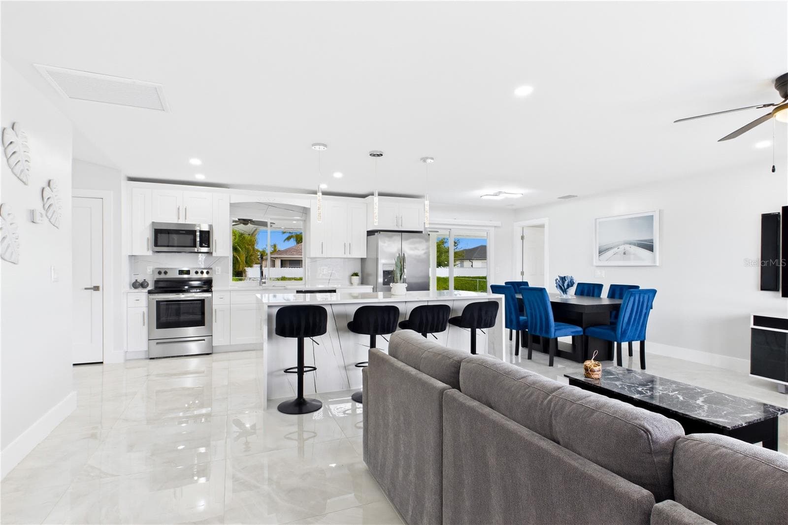 Inside, stunning 32x32 POLISHED MARBLE-LOOK PORCELAIN TILE flows throughout, complemented by bright neutral finishes, upgraded lighting, recessed LEDs & contemporary ceiling fans. - 256 SE SANTA BARBARA PL, CAPE CORAL