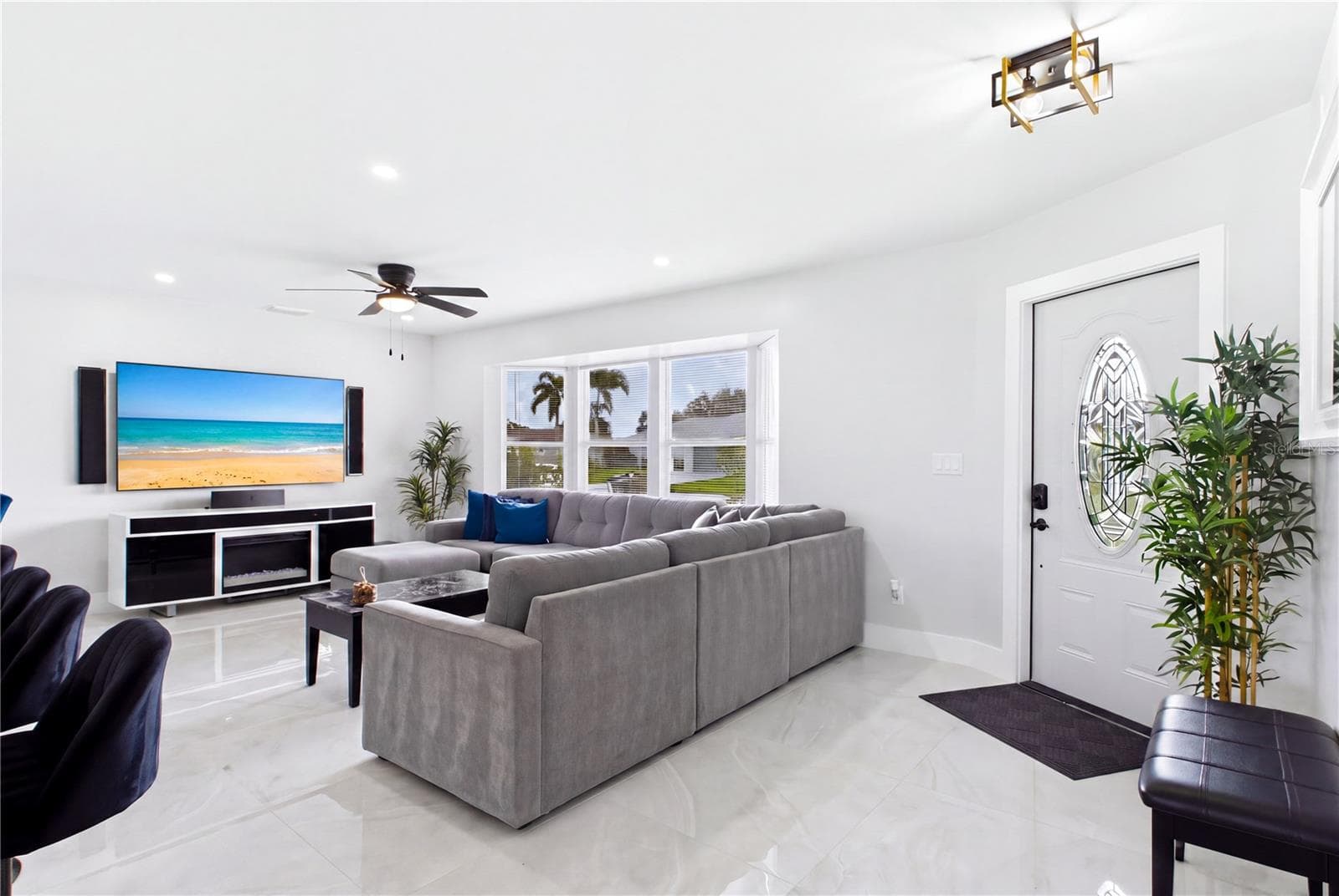 Expansive windows fill the space w/ abundant NATURAL LIGHT. Gorgeous polished MARBLE-LOOK PORCELAIN TILE creates a seamless, sophisticated look throughout. - 256 SE SANTA BARBARA PL, CAPE CORAL