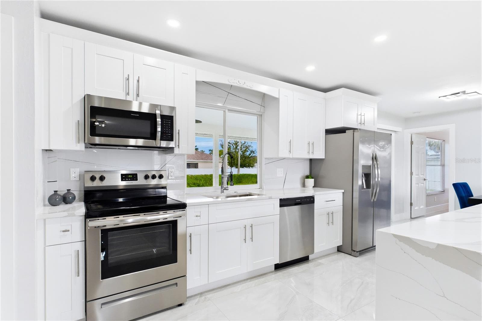 Modern pendant lighting, abundant cabinetry & open-concept design make this space equally beautiful & functional. - 256 SE SANTA BARBARA PL, CAPE CORAL
