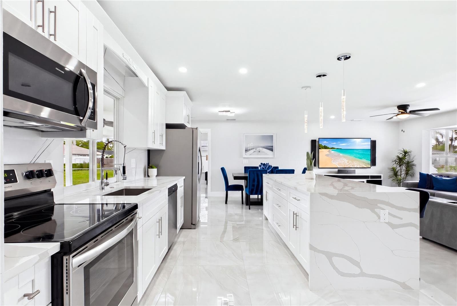 The OVERSIZED WATERFALL ISLAND anchors the kitchen, offering generous prep space, additional storage & comfortable seating for casual dining and entertaining. - 256 SE SANTA BARBARA PL, CAPE CORAL