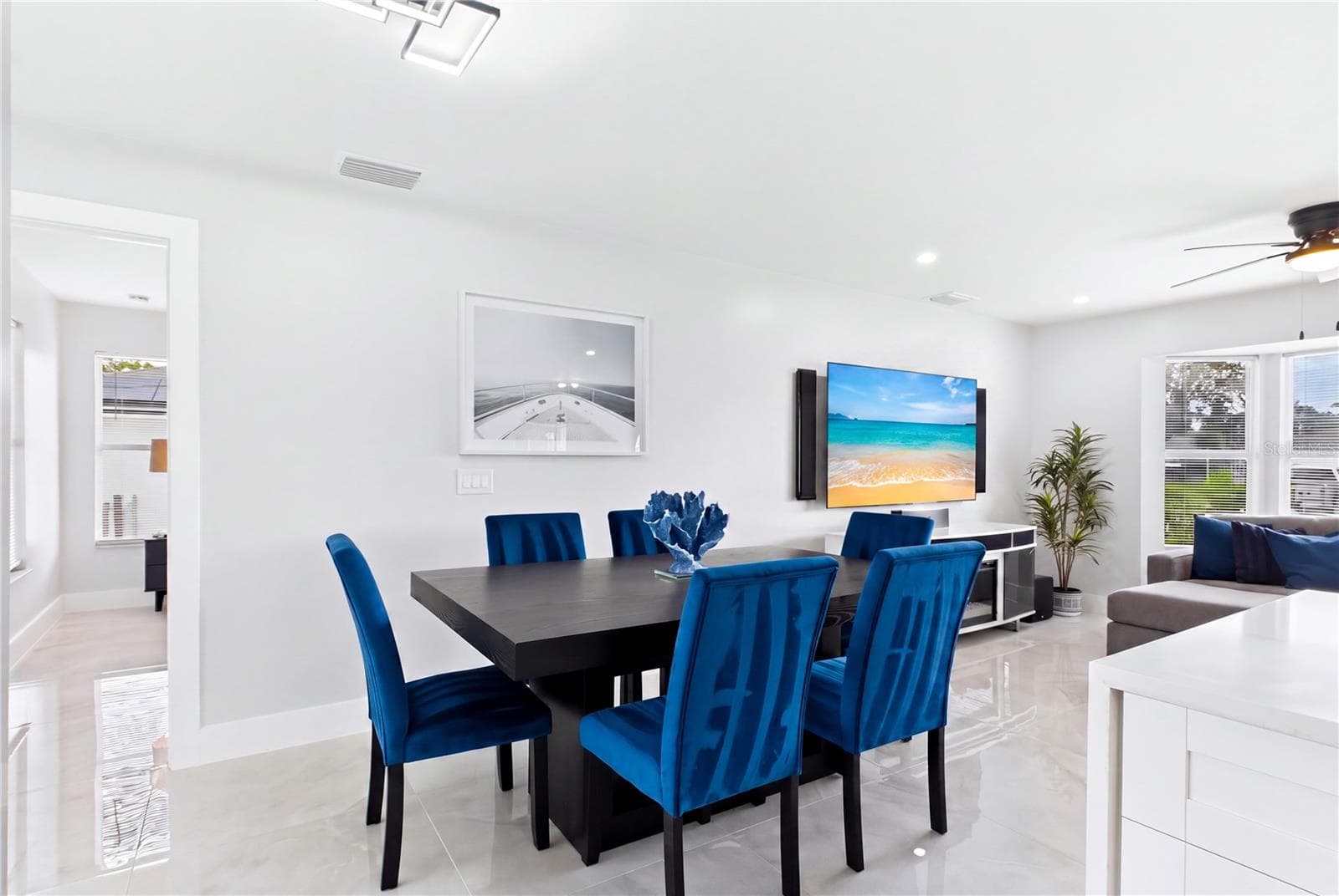 Contemporary lighting adds a stylish focal point while the polished marble-look porcelain flooring creates a cohesive, sophisticated feel. - 256 SE SANTA BARBARA PL, CAPE CORAL